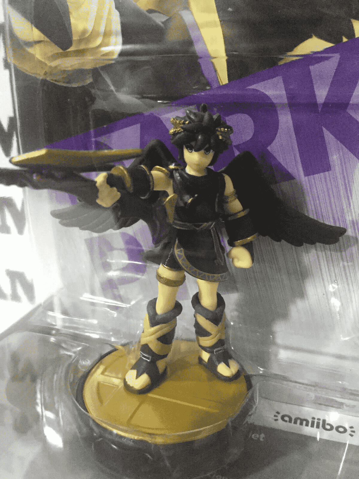 Eine Dark Pit Amiibo-Figur mit schwarzen Flügeln und goldenen Details in ihrer Plastikverpackung.