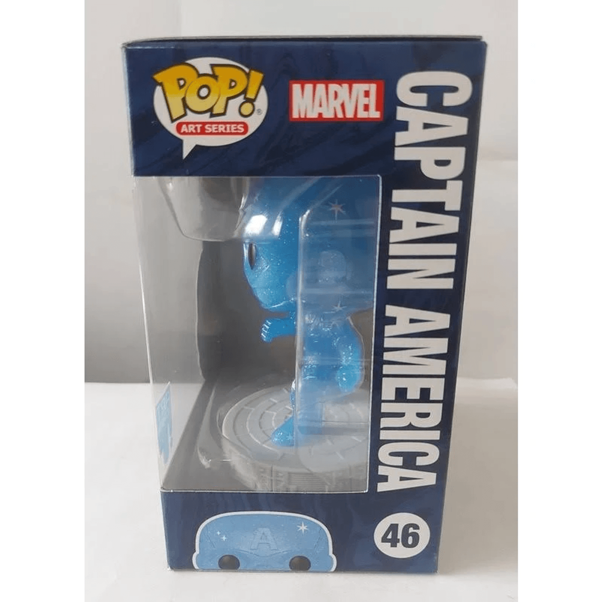 Una figura de vinilo Funko Pop de Capitán América azul brillante dentro de su caja de embalaje original.