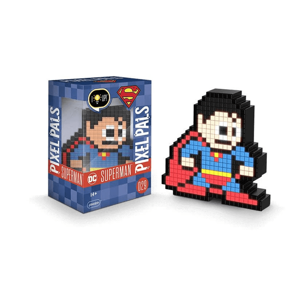 Una figura pixelada de Superman junto a su caja de embalaje azul y roja sobre fondo blanco.