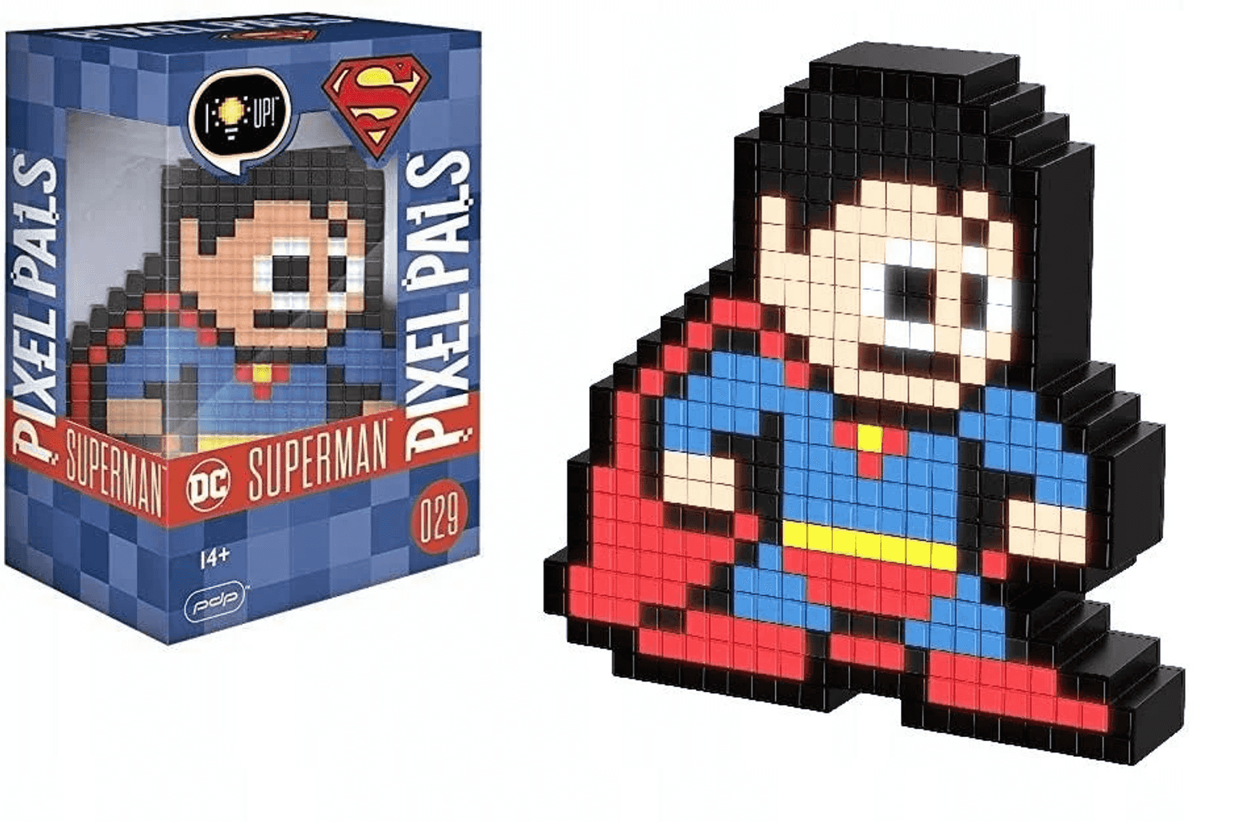 Figura de Superman de Pixel Pals en diseño de 8 bits junto a su caja de embalaje azul y roja.