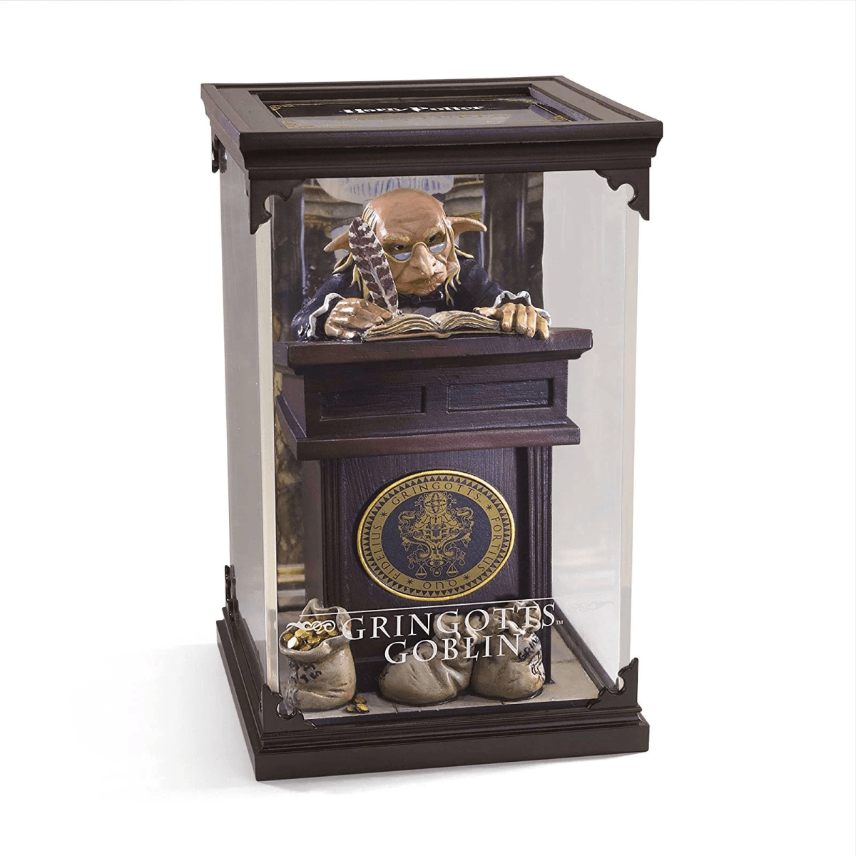 Una figura de duende de Gringotts en una vitrina con un escritorio, bolsas de monedas y el logotipo.