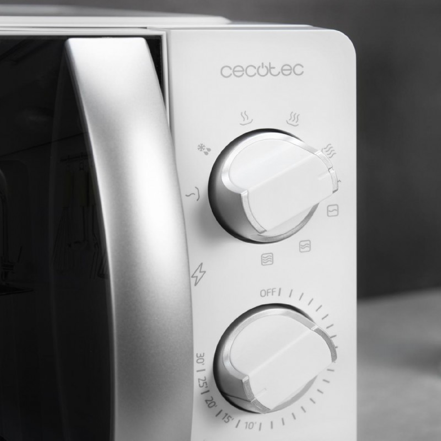 Primer plano de un horno microondas blanco Cecotec con dos mandos de control redondos y un gran tirador plateado.