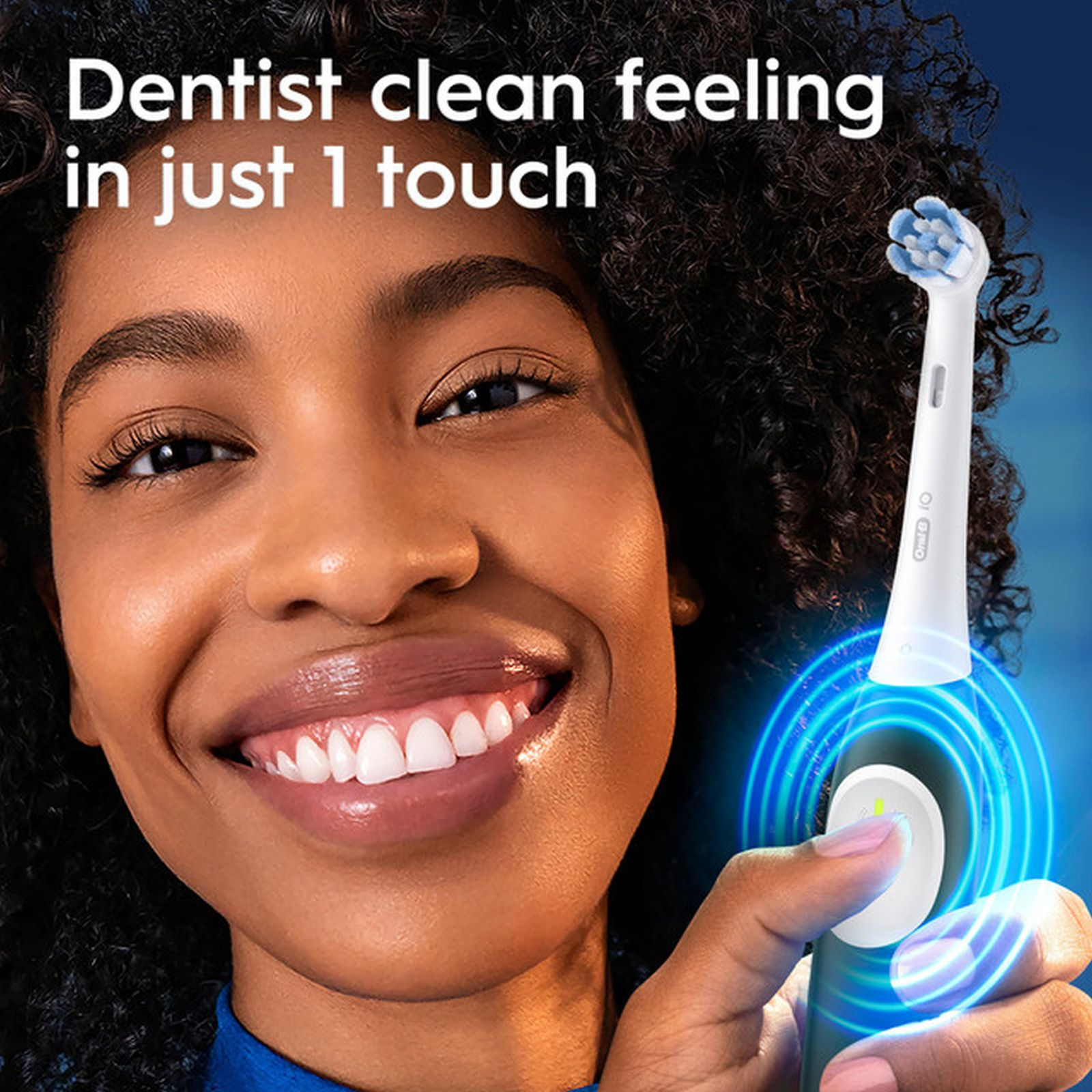 Donna sorridente tiene uno spazzolino elettrico con anelli blu luminosi.