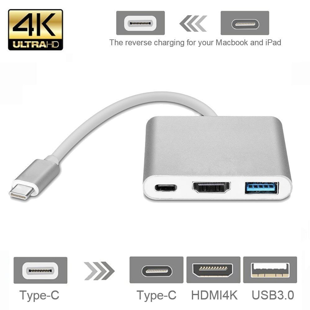 Egy ezüst színű USB-C hub HDMI, USB és USB-C portokkal, valamint egy csatlakoztatott kábellel.