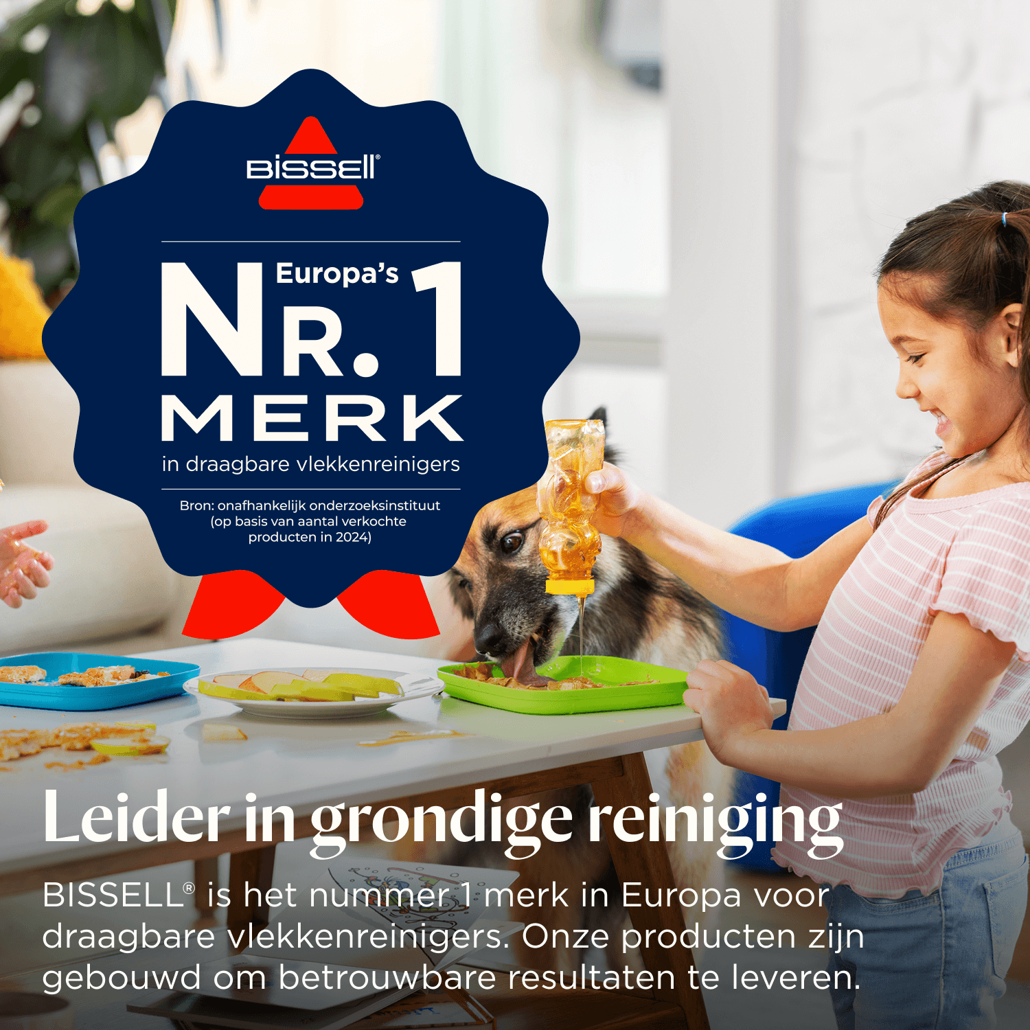 Ein Mädchen füttert einen Hund mit Honig an einem Tisch in einem Raum mit einem Bissell-Werbebanner.