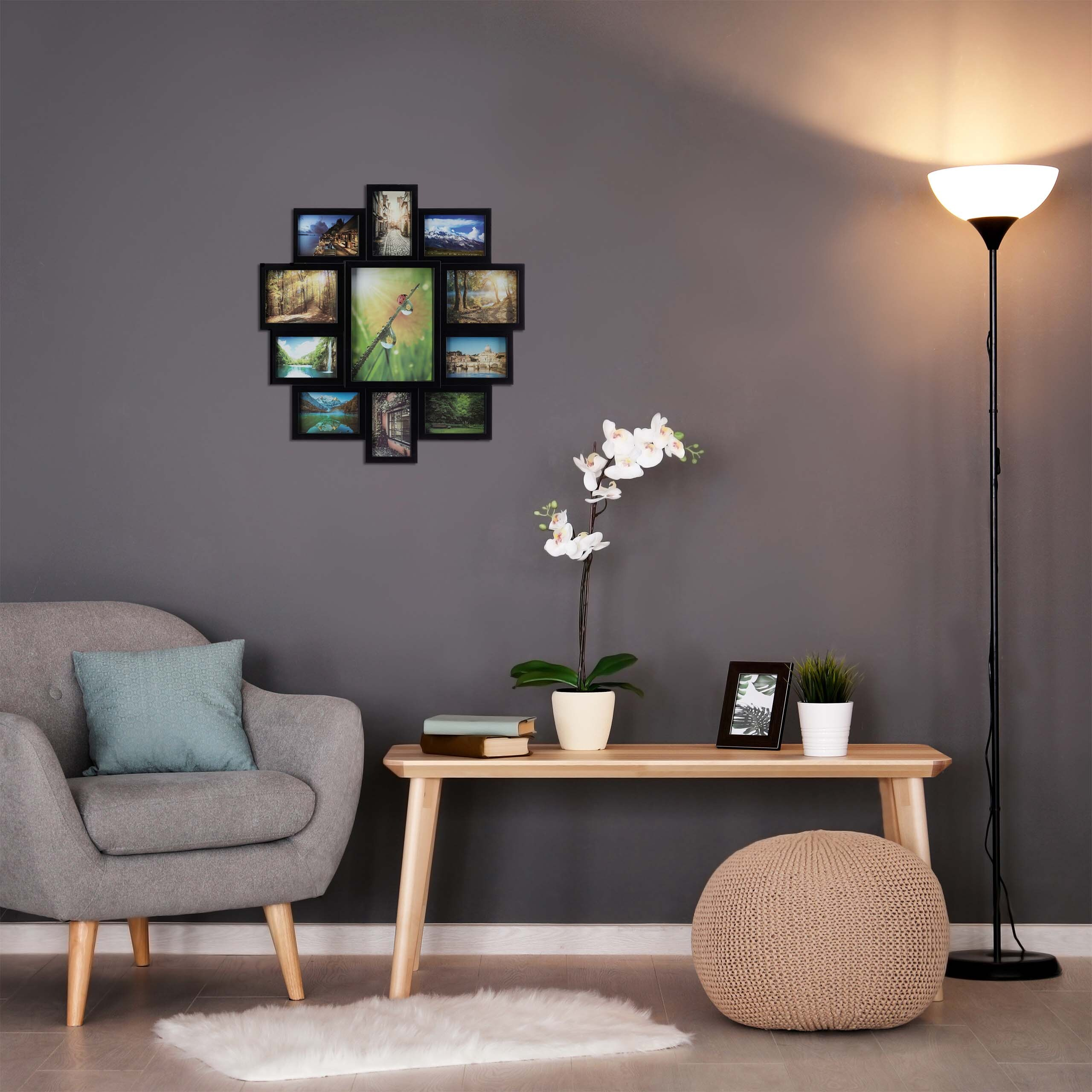 Ein grauer Sessel, ein Holzkonsolentisch mit Pflanzen und Fotorahmen, eine Fotocollage an der Wand und eine Stehlampe.
