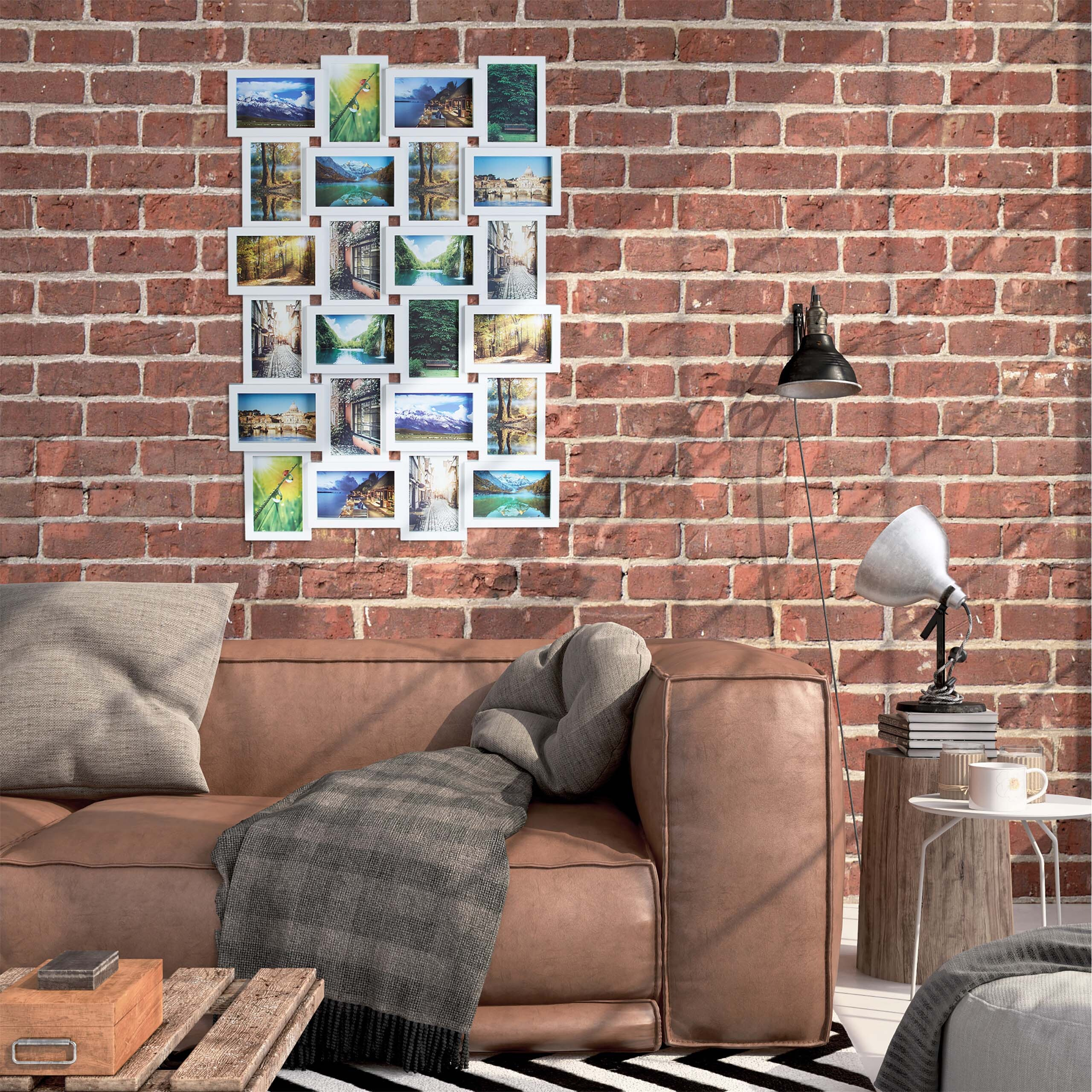 Ein braunes Ledersofa mit Decke und Kissen steht vor einer roten Ziegelwand, neben einer Fotocollage und Lampe.
