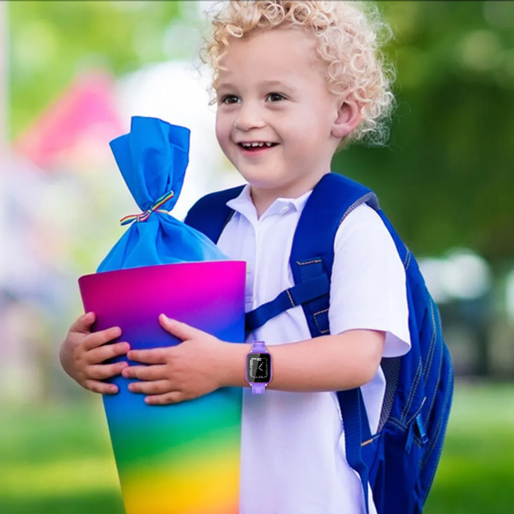 Ein lockiges Kind mit Schultüte und blauem Rucksack lächelt.