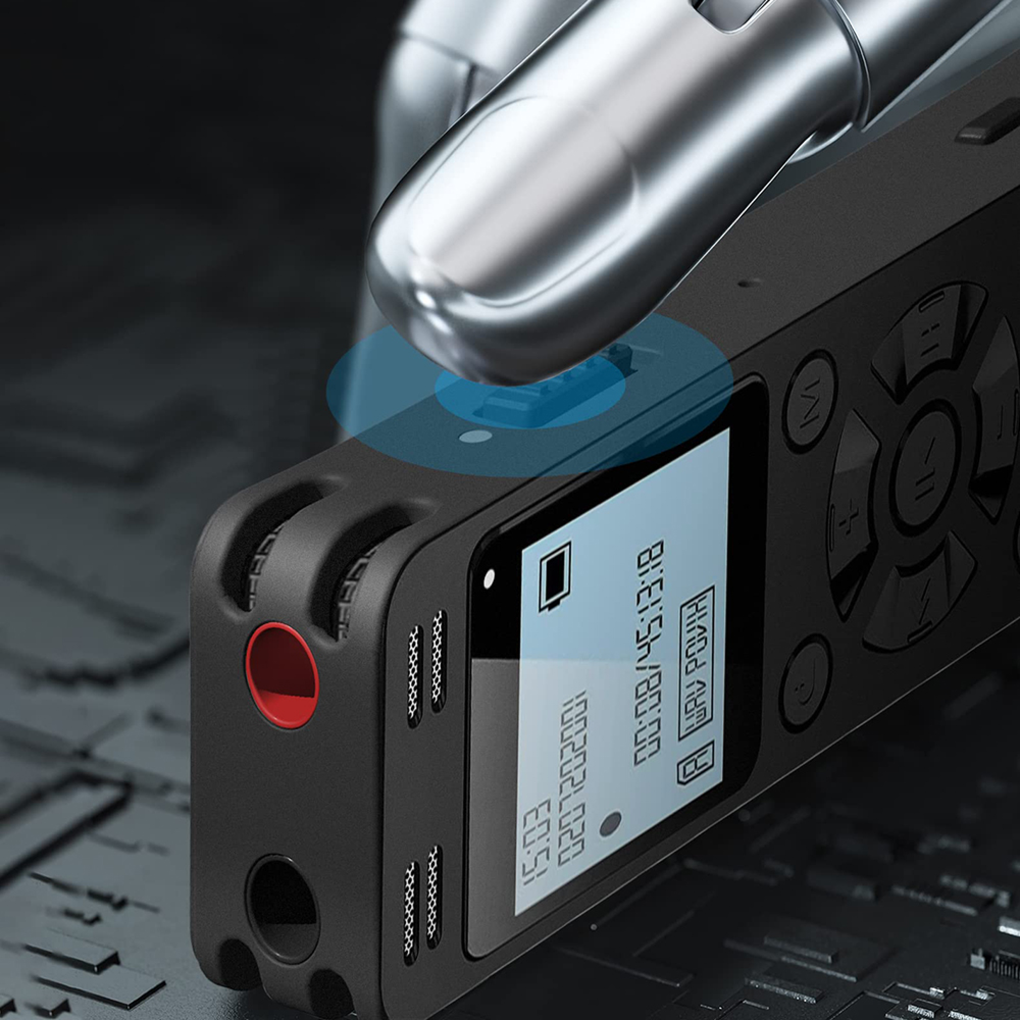 Ein silberner Roboterfinger drückt einen Knopf auf einem schwarzen Sprachrekorder mit digitalem Bildschirm.