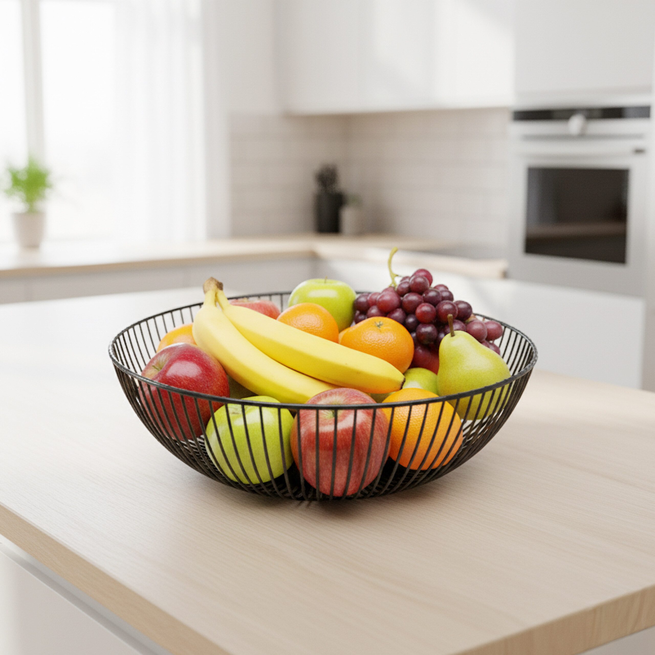 Ein schwarzer Drahtkorb voller frischem Obst wie Bananen, Äpfeln, Trauben und Orangen steht in einer Küche.