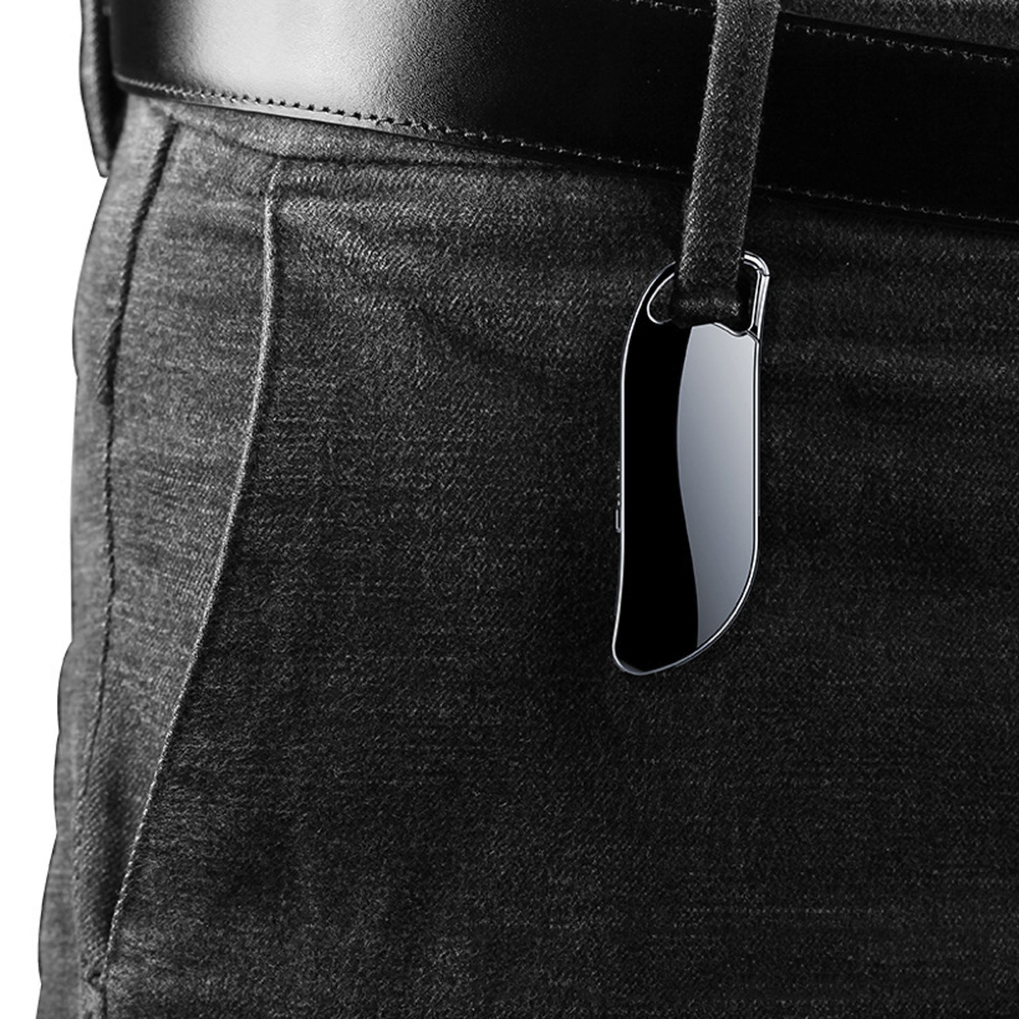 Ein schlankes, schwarzes elektronisches Gerät hängt an einer Gürtelschlaufe von dunklen Jeans unter einem schwarzen Gürtel.
