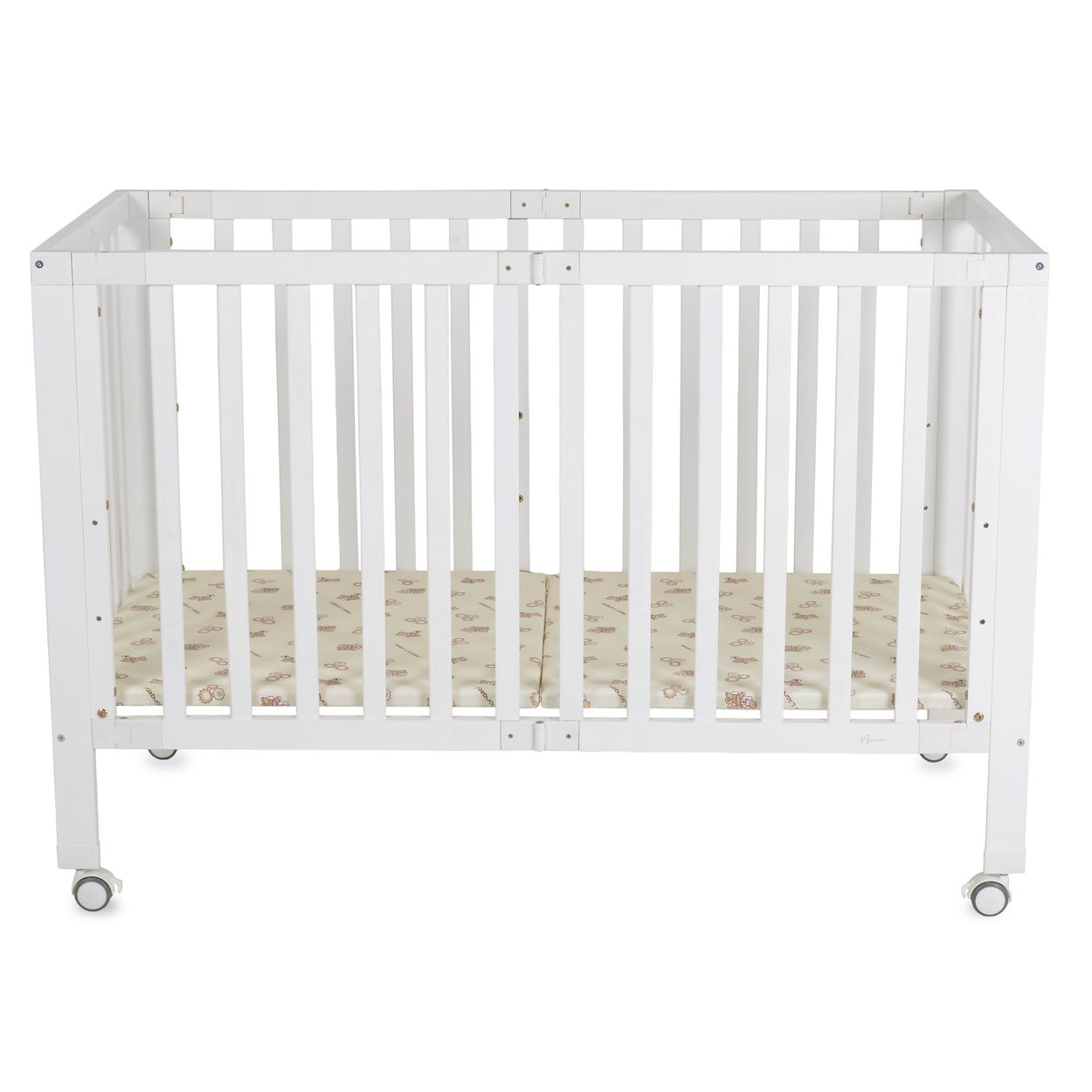 Ein weißes Babybett mit Rollen und einer gemusterten Matratze auf einem neutralen Hintergrund.