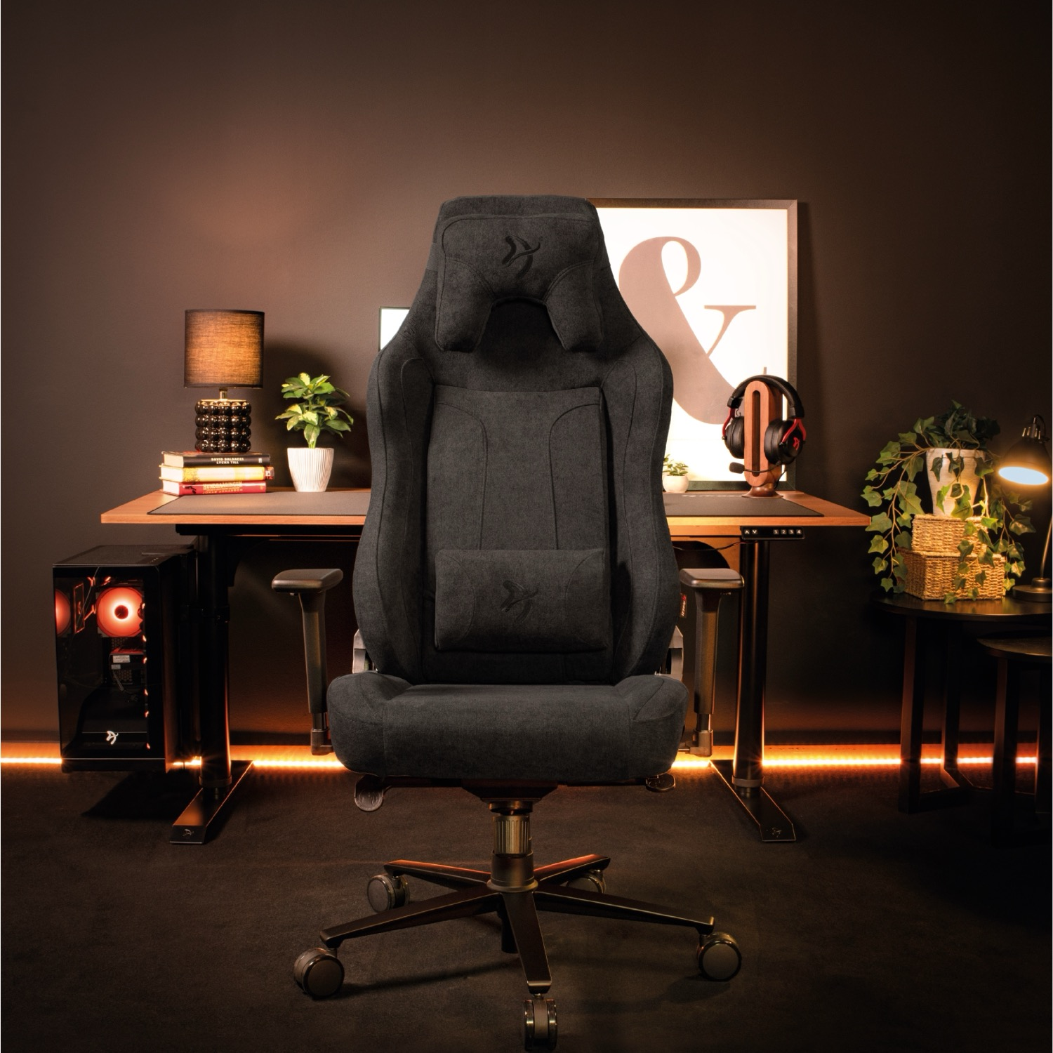 Una sedia da gaming nera ergonomica si trova in una stanza elegante davanti a una scrivania con PC.