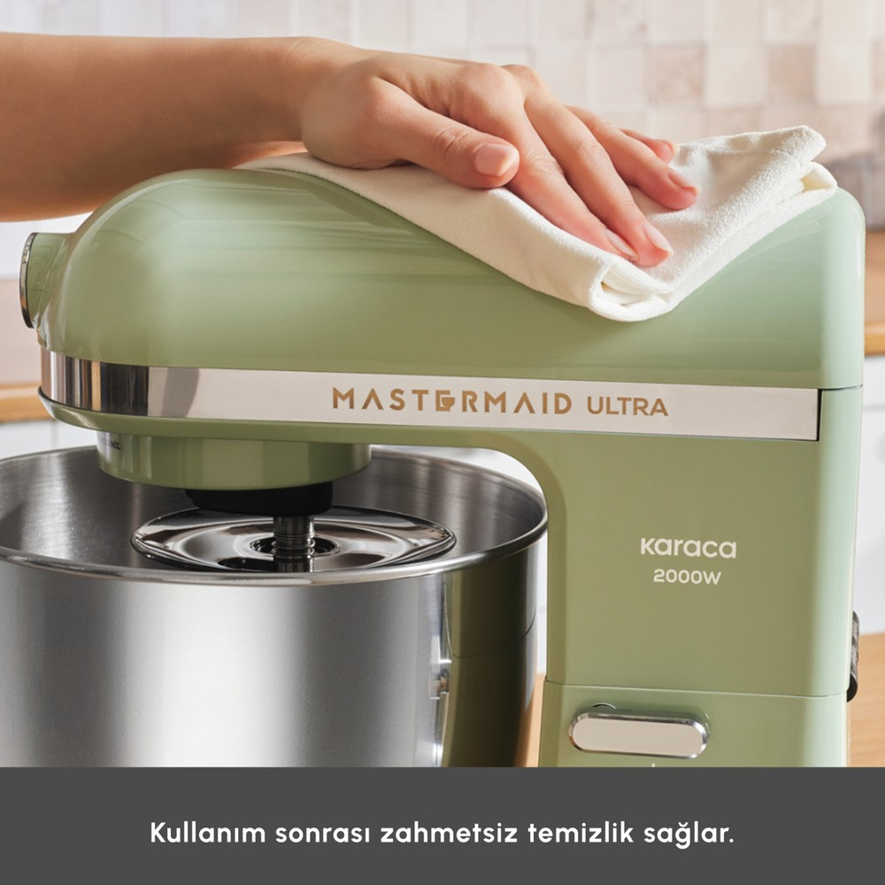 Bir el, beyaz bir bezle nane yeşili mutfak robotunu siliyor.