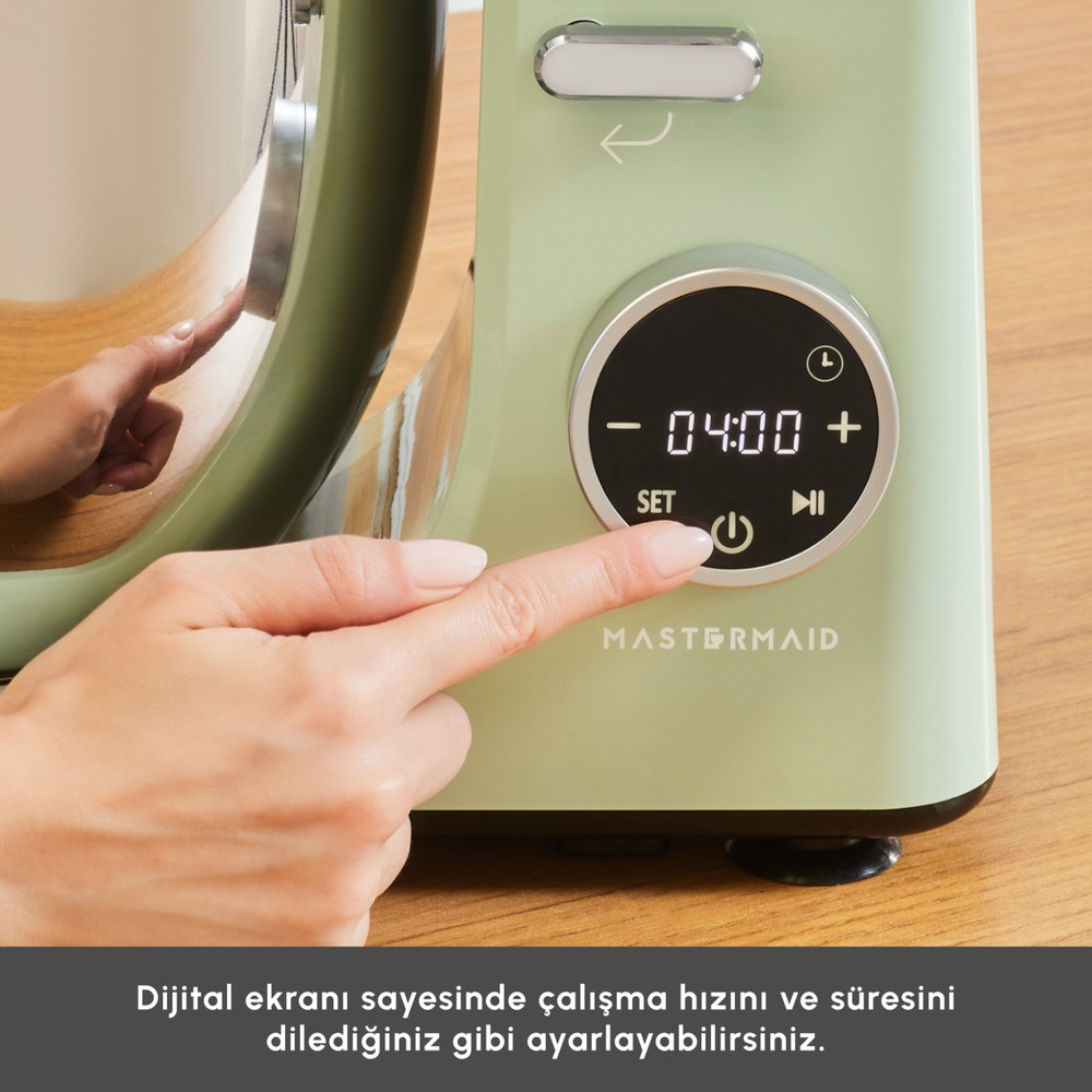 Dijital ekranlı açık yeşil Mastermaid cihazının güç düğmesine basan bir el.