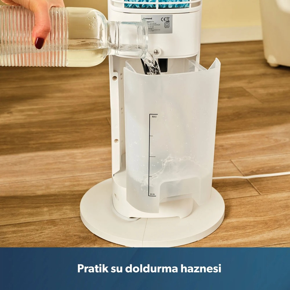 Ahşap zeminde duran beyaz bir hava soğutucunun su haznesine cam şişeden su dolduran bir el.