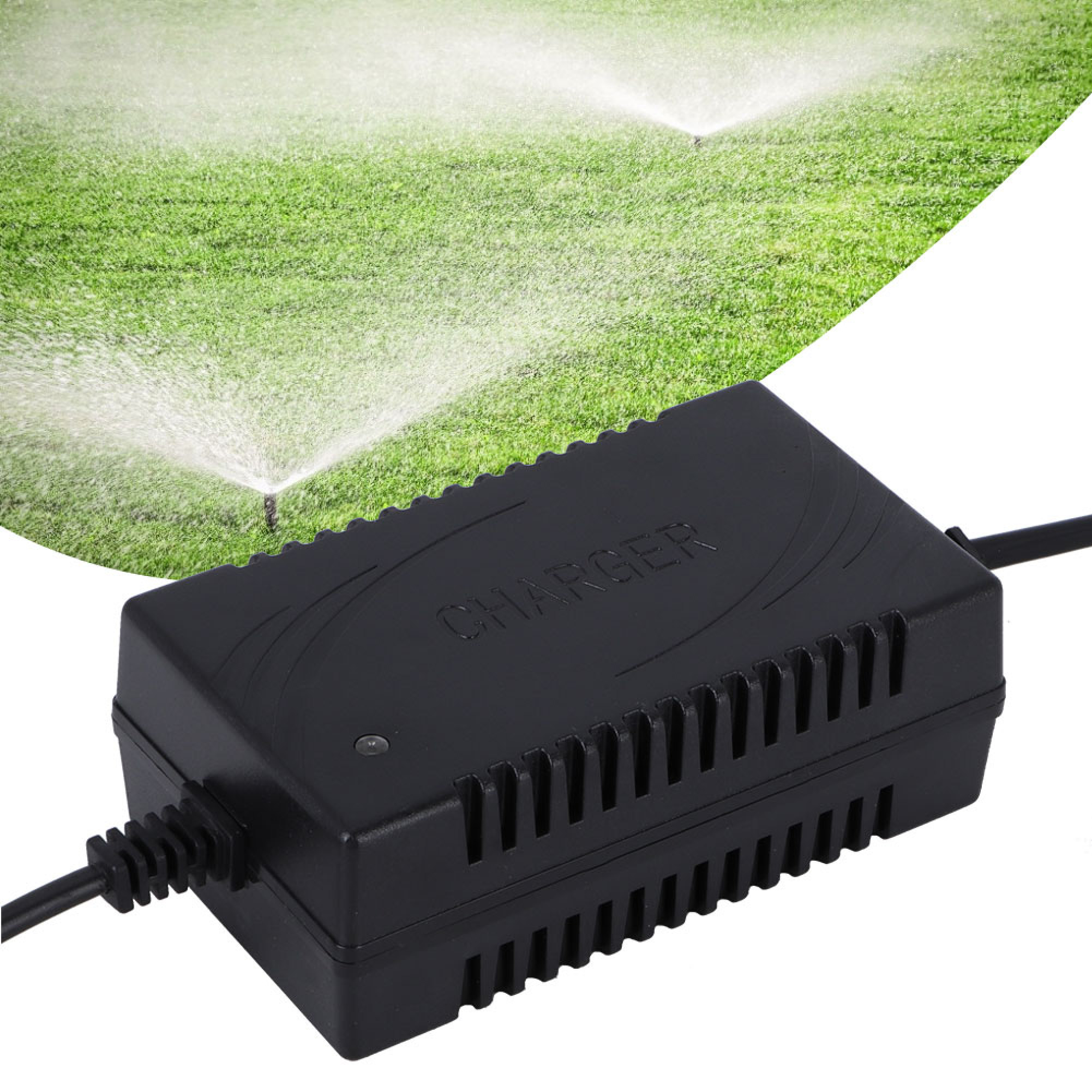 Ein schwarzes Ladegerät mit Kabeln vor einer Rasenfläche mit Sprinklern.