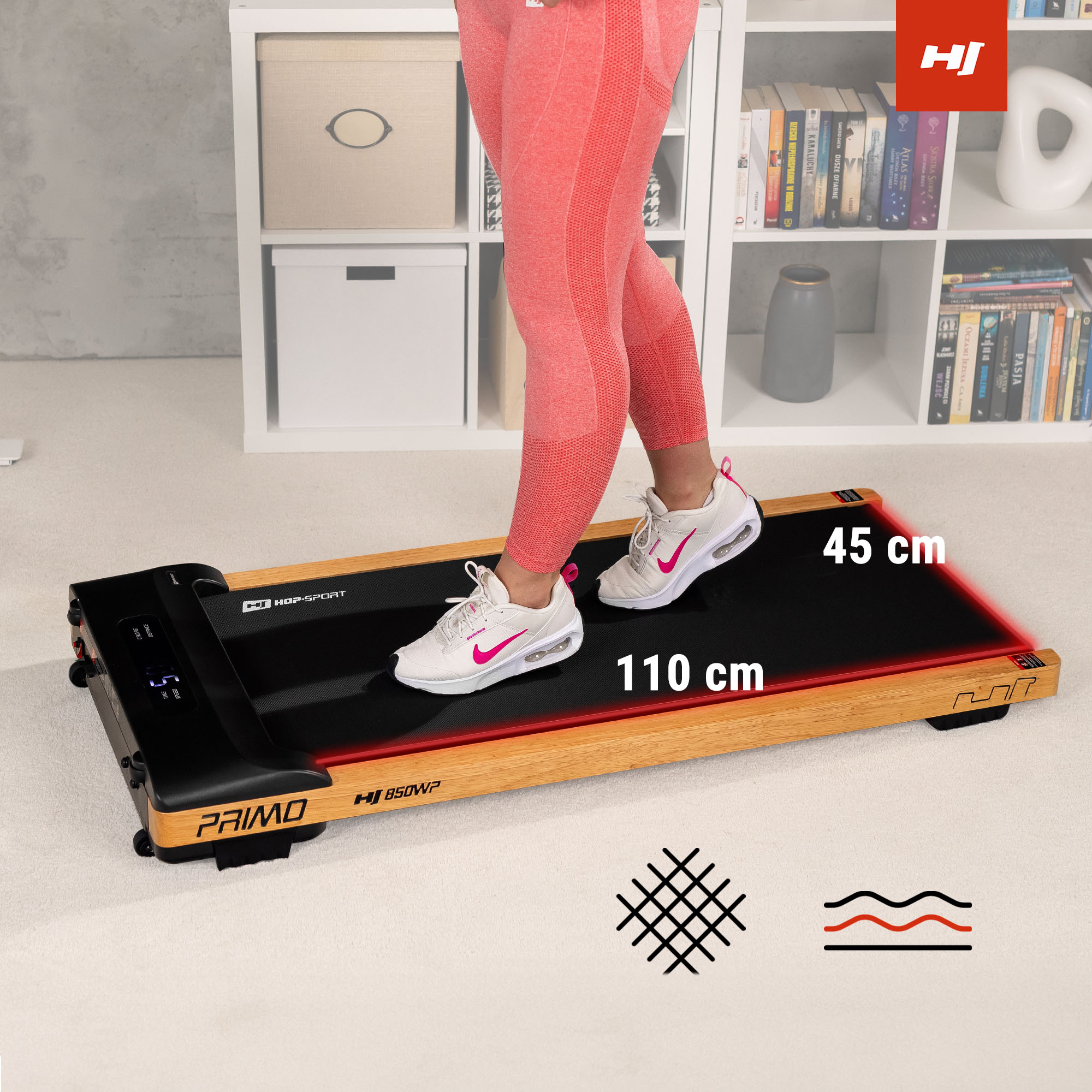 Person in rosafarbenen Leggings steht auf einem kompakten Holzlaufband mit 110x45 cm. Regale im Hintergrund.