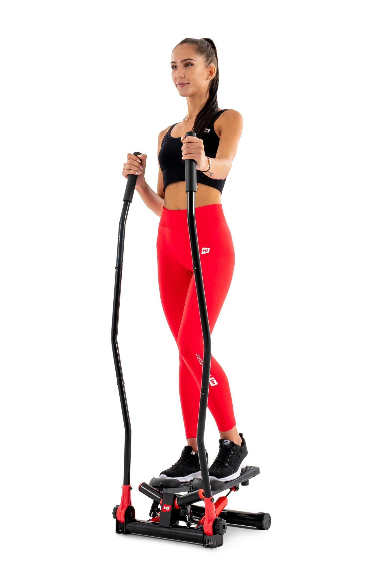 Eine Frau in Sportkleidung trainiert auf einem Heimtrainer.