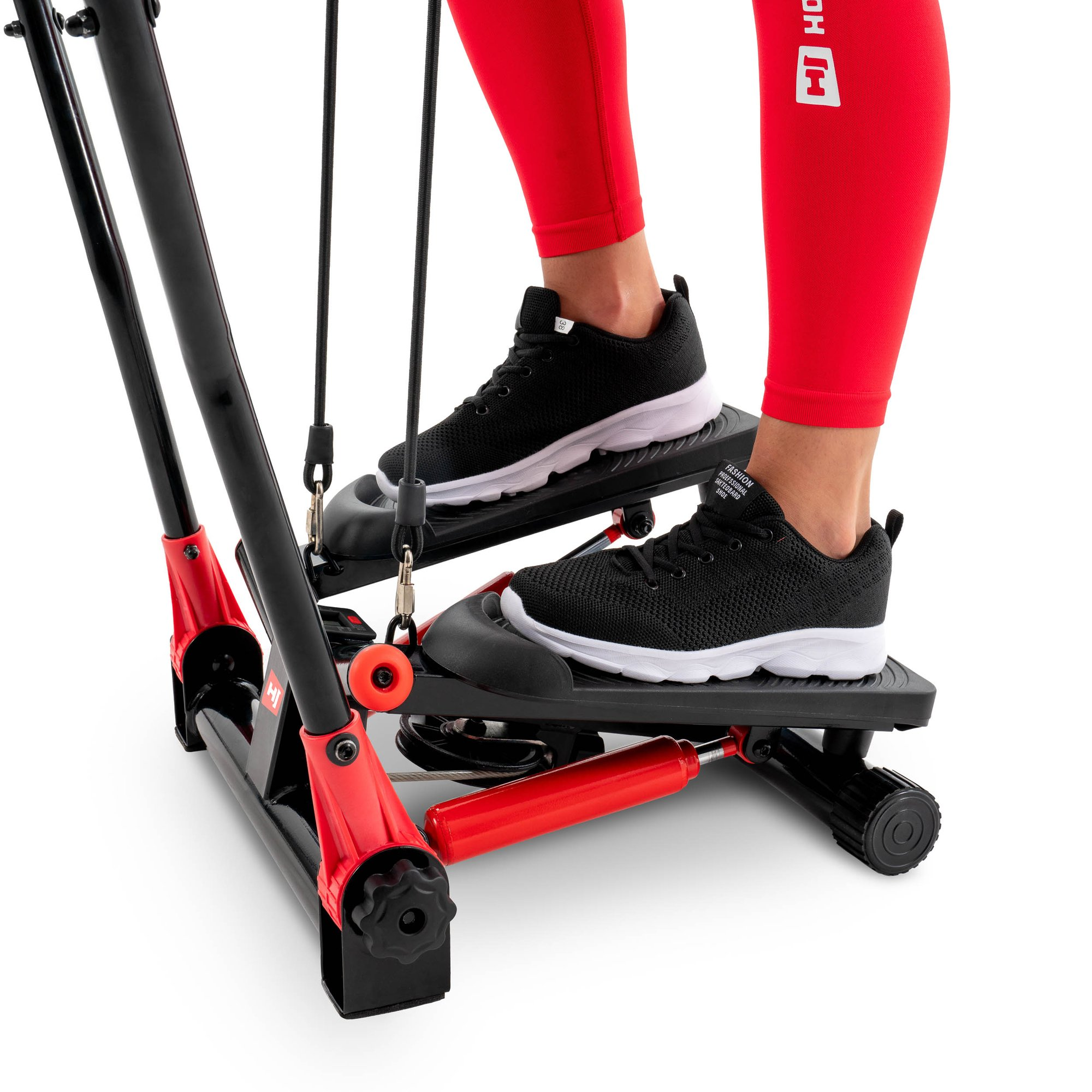 Person in roten Leggings und schwarzen Schuhen auf einem rot-schwarzen Heimtrainer-Stepper gegen weißen Hintergrund.