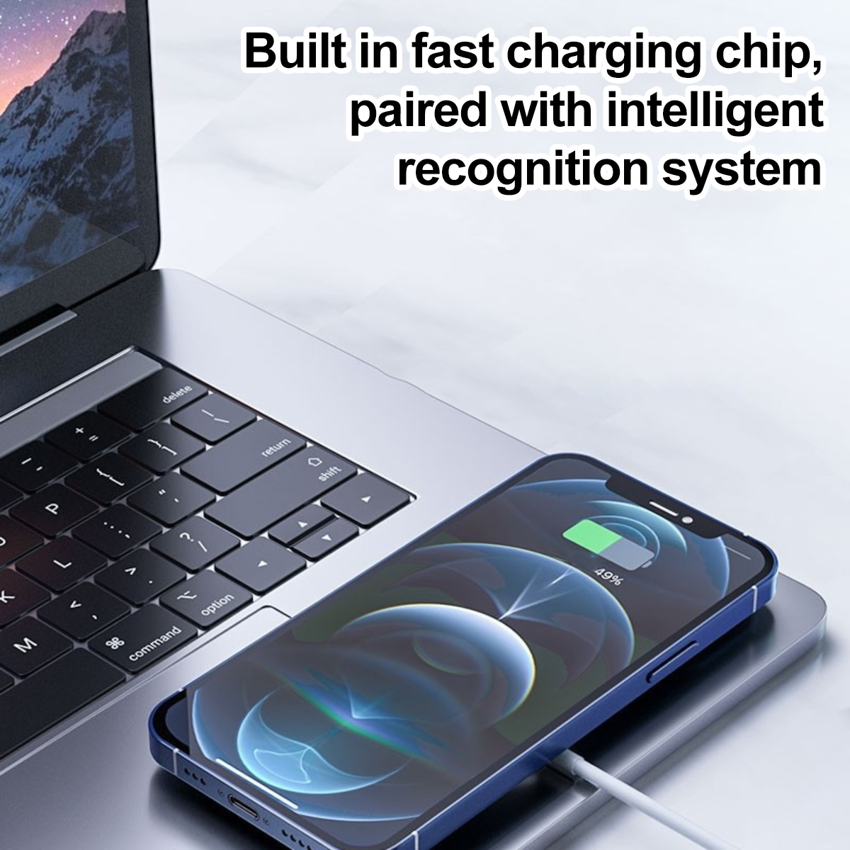 Ein Smartphone mit Ladekabel liegt auf einer Laptop-Oberfläche, Text oben.