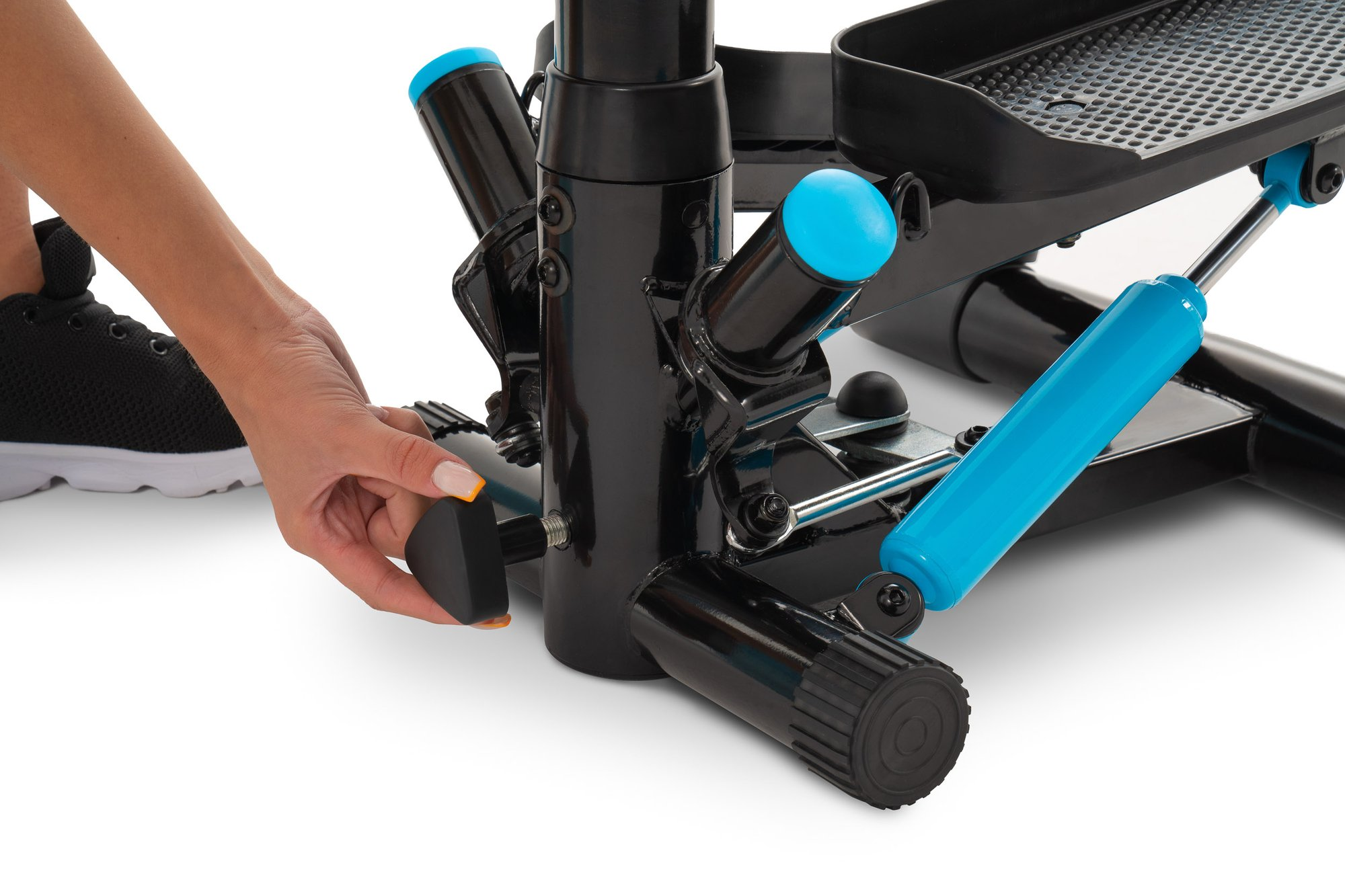 Eine Hand dreht den schwarzen Einstellknopf an der Basis eines blauen und schwarzen Steppers.