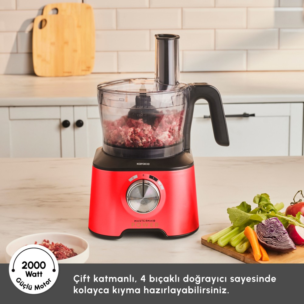 Kırmızı Karaca mutfak robotu, içinde et ve yanında sebzelerle tezgâh üzerinde duruyor.