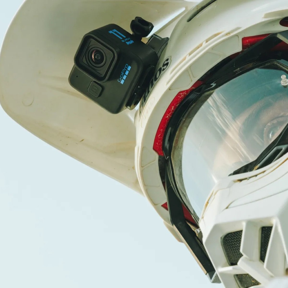 Eine GoPro-Kamera ist an der Oberseite eines weißen Motocross-Helms mit Schutzbrille montiert.