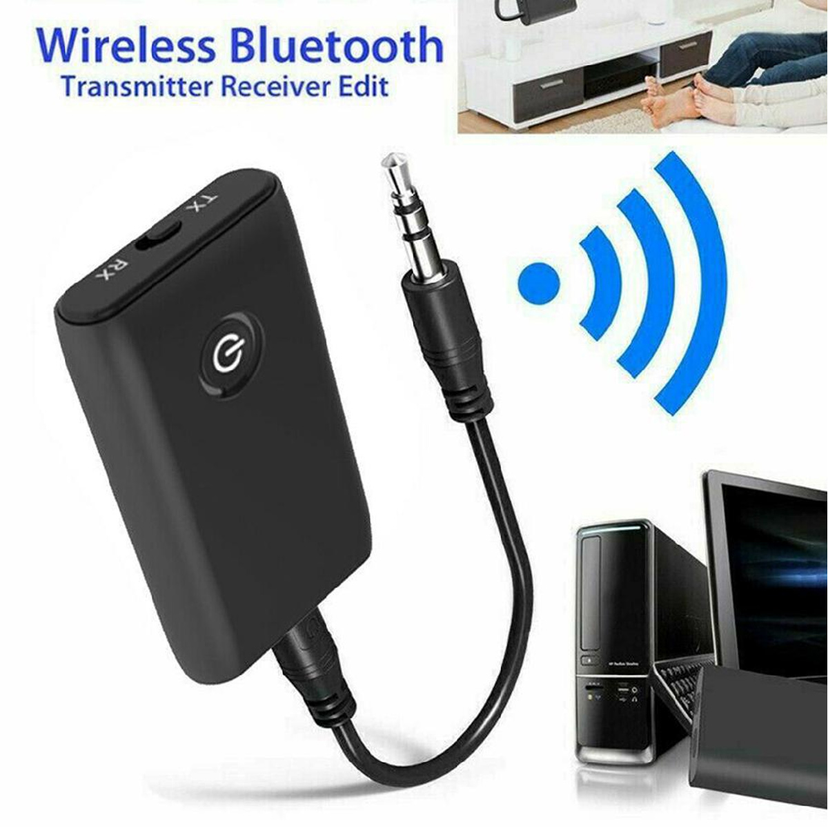Schwarzer kabelloser Bluetooth-Sender und -Empfänger mit 3,5-mm-Audiokabel und Computern im Hintergrund.