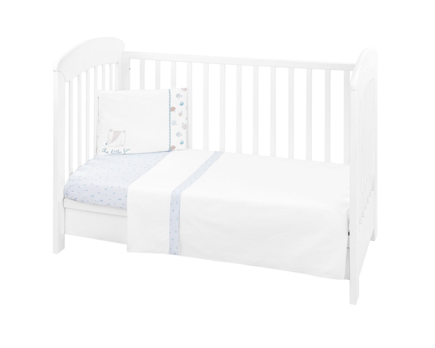 Ein weißes Babybett mit weißer Bettwäsche, blauen Punkten und Kissen auf weißem Grund.