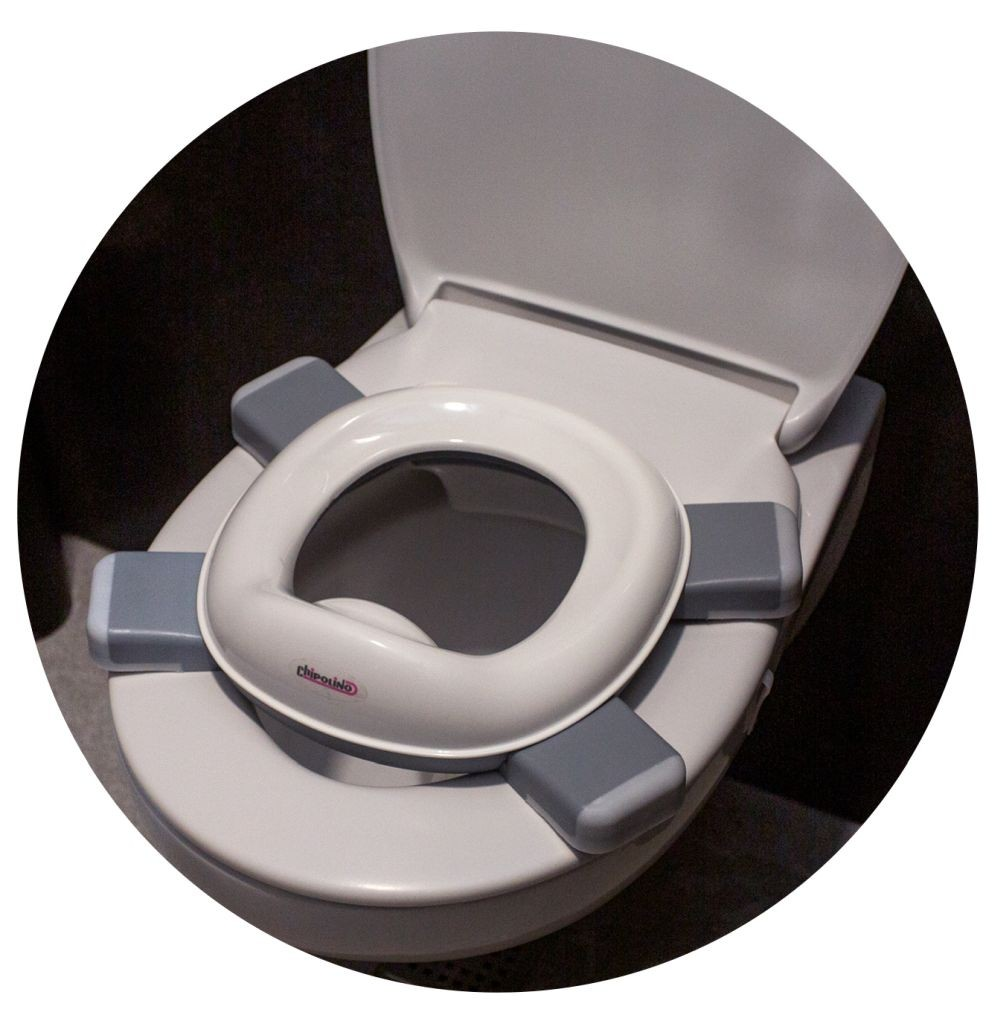 Ein weißer Kindertoilettensitz mit grauen Akzenten ist auf einer Standardtoilette platziert.