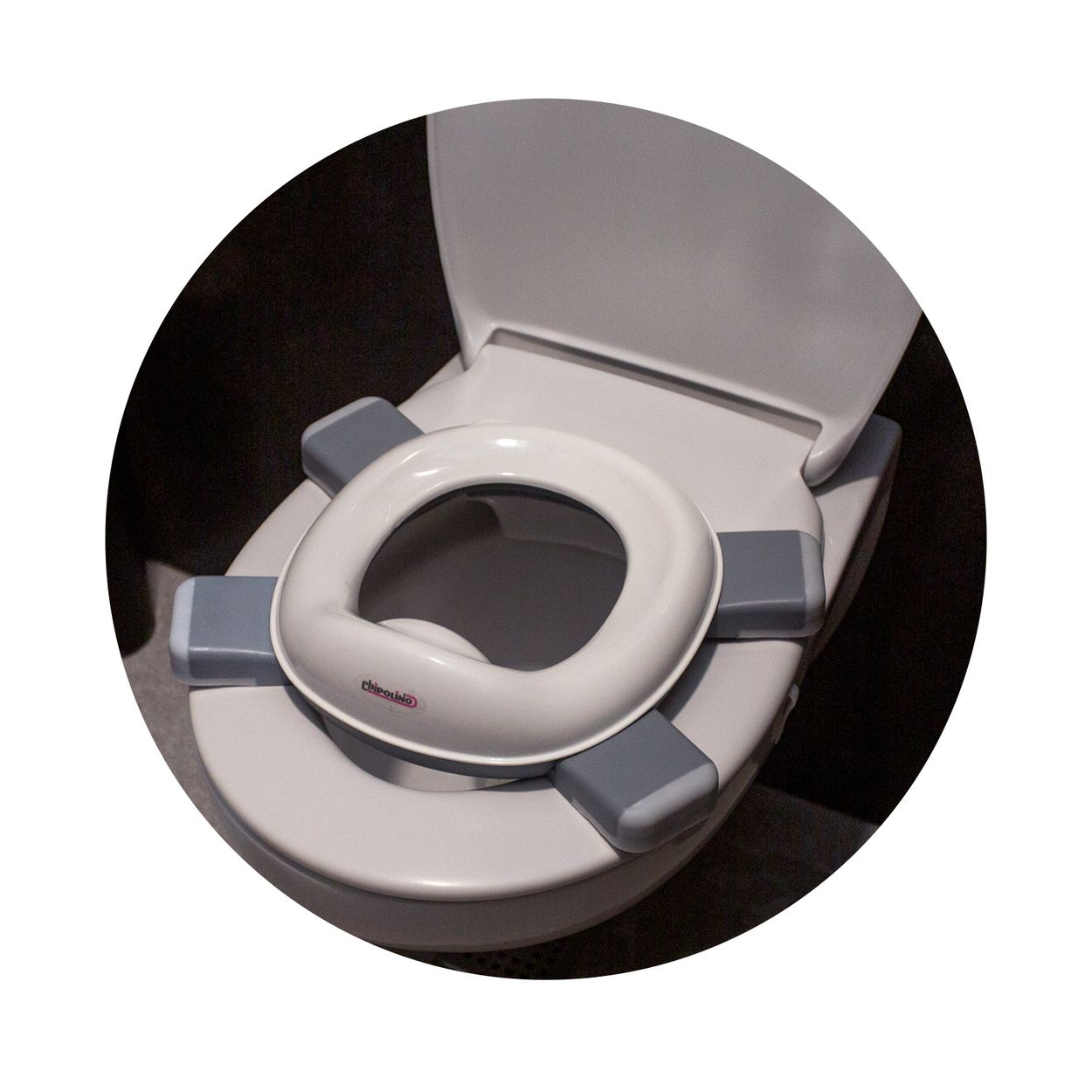 Ein weiß-grauer Kindertoilettensitz sicher auf einer Standard-Toilettenschüssel platziert.