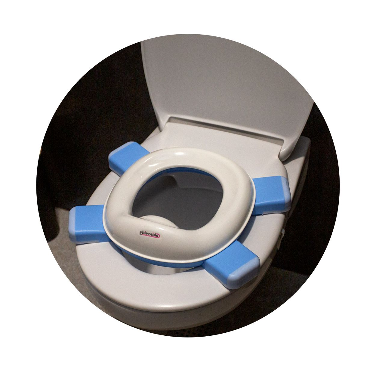 Ein weiß-blauer Kindertoilettensitz ist auf einer Standardtoilette platziert.