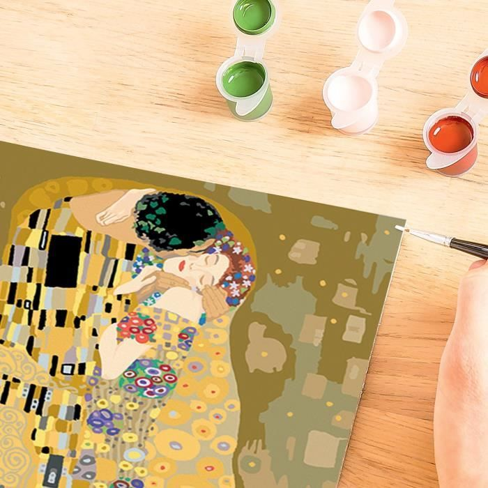 Eine Hand malt Gustav Klimts Der Kuss mit kleinen Farbtöpfen auf Holz.