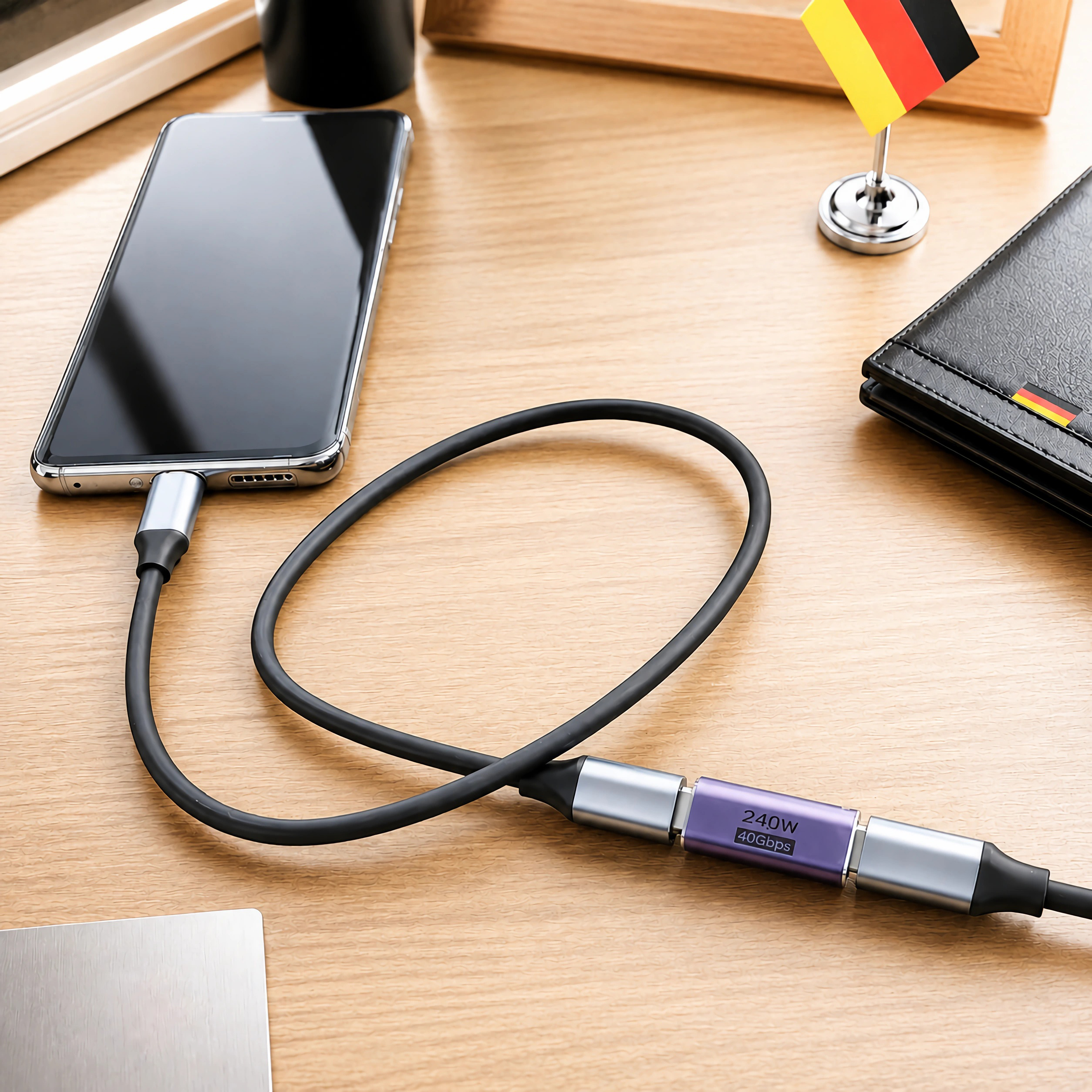 Ein schwarzes Smartphone auf Holz, verbunden mit einem Kabel und einem lila Adapter.