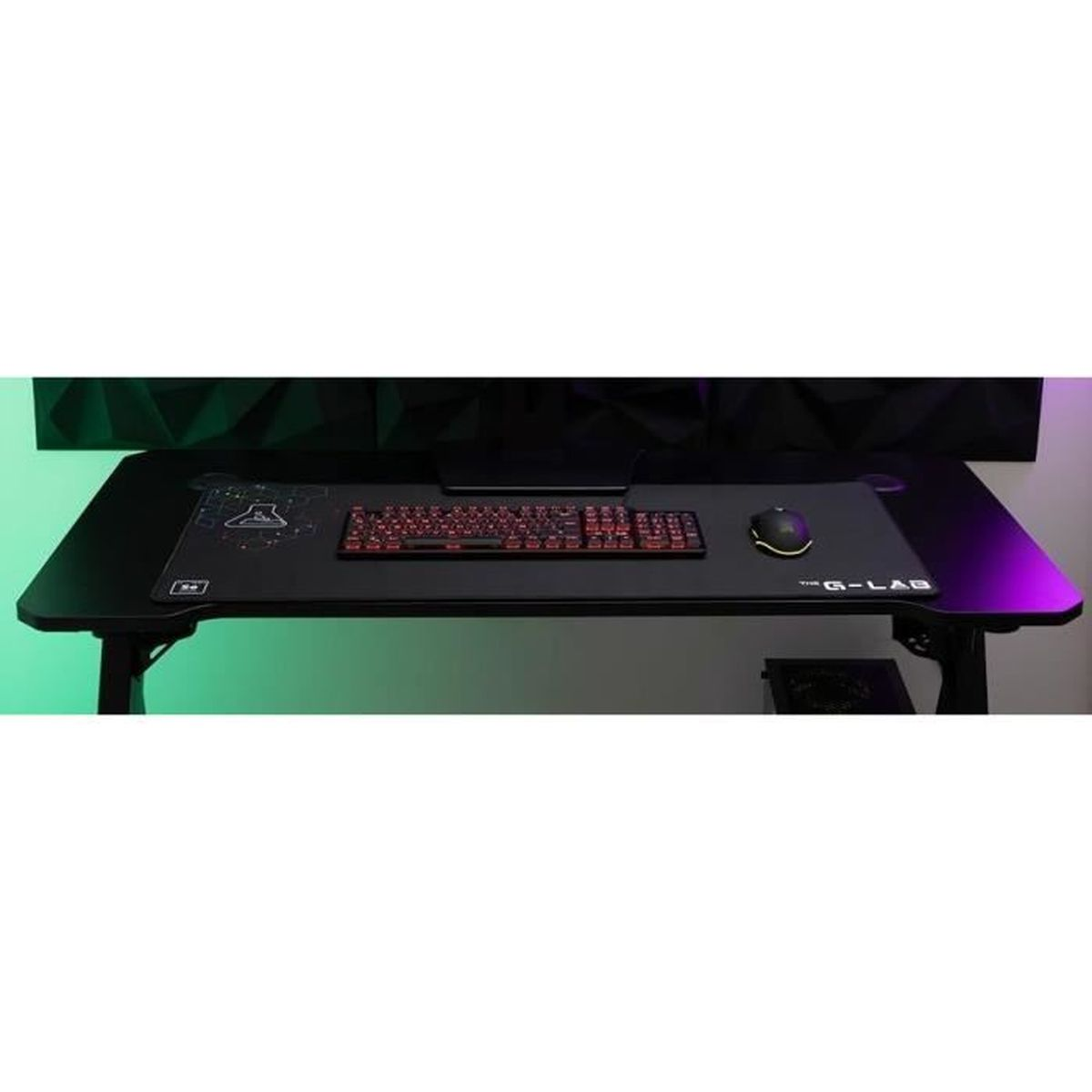Ein schwarzer Gaming-Schreibtisch mit einer großen Matte, roter Tastatur und Maus. Das Setup ist in grün und lila beleuchtet.