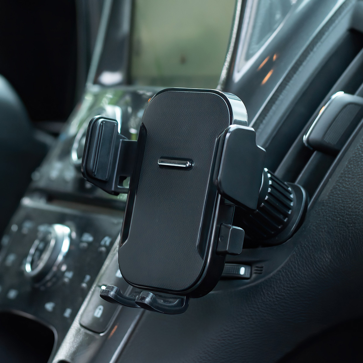 Ein schwarzer Handyhalter ist an der Lüftung des Armaturenbretts eines Autos angebracht.