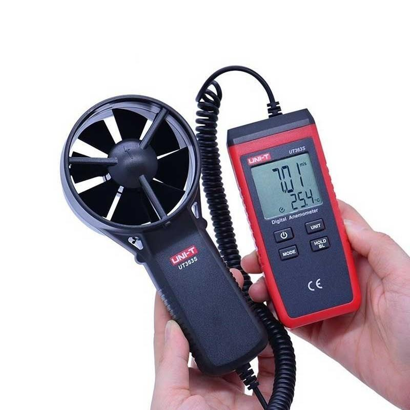 Beyaz arka planda ellerde tutulan pervaneli sensörlü kırmızı ve siyah dijital anemometre.