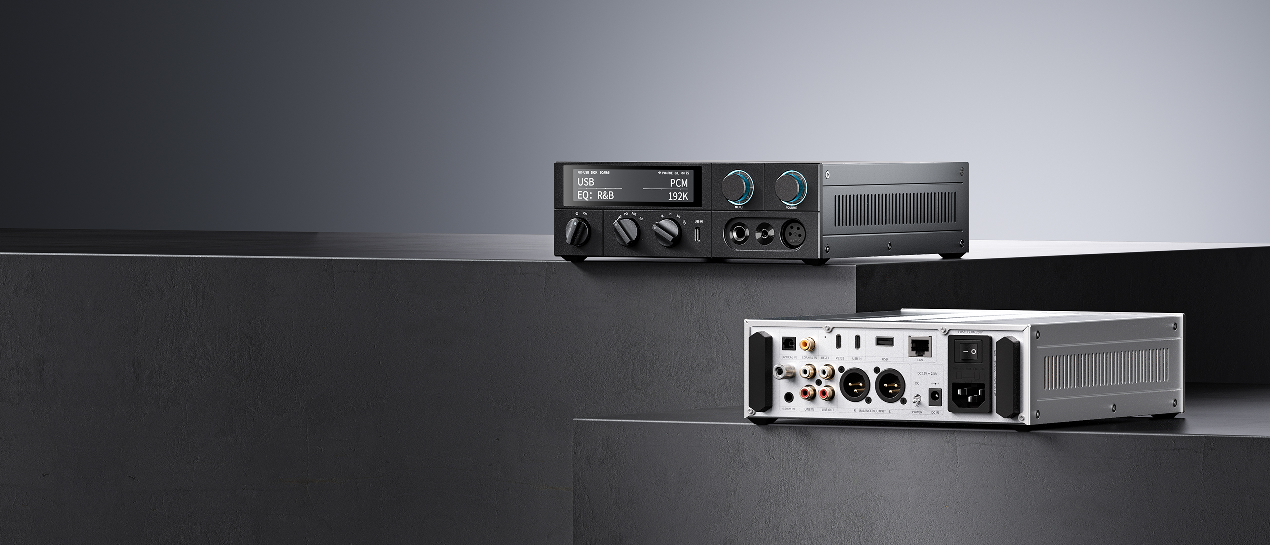 Dos amplificadores de audio modernos en bloques oscuros escalonados, uno muestra el panel frontal y el otro el trasero.