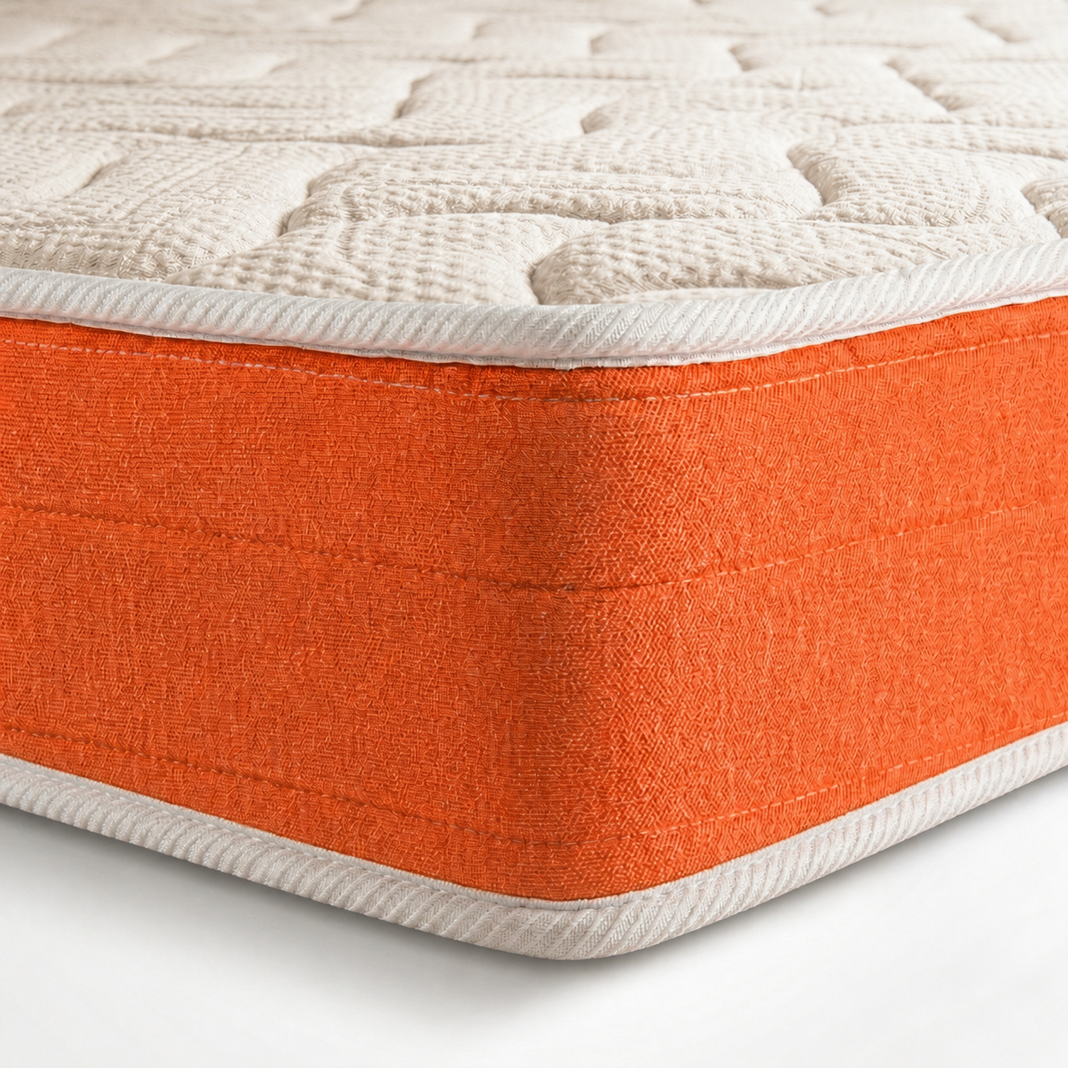 Primer plano de un colchón con la parte superior acolchada blanca y un borde naranja brillante.