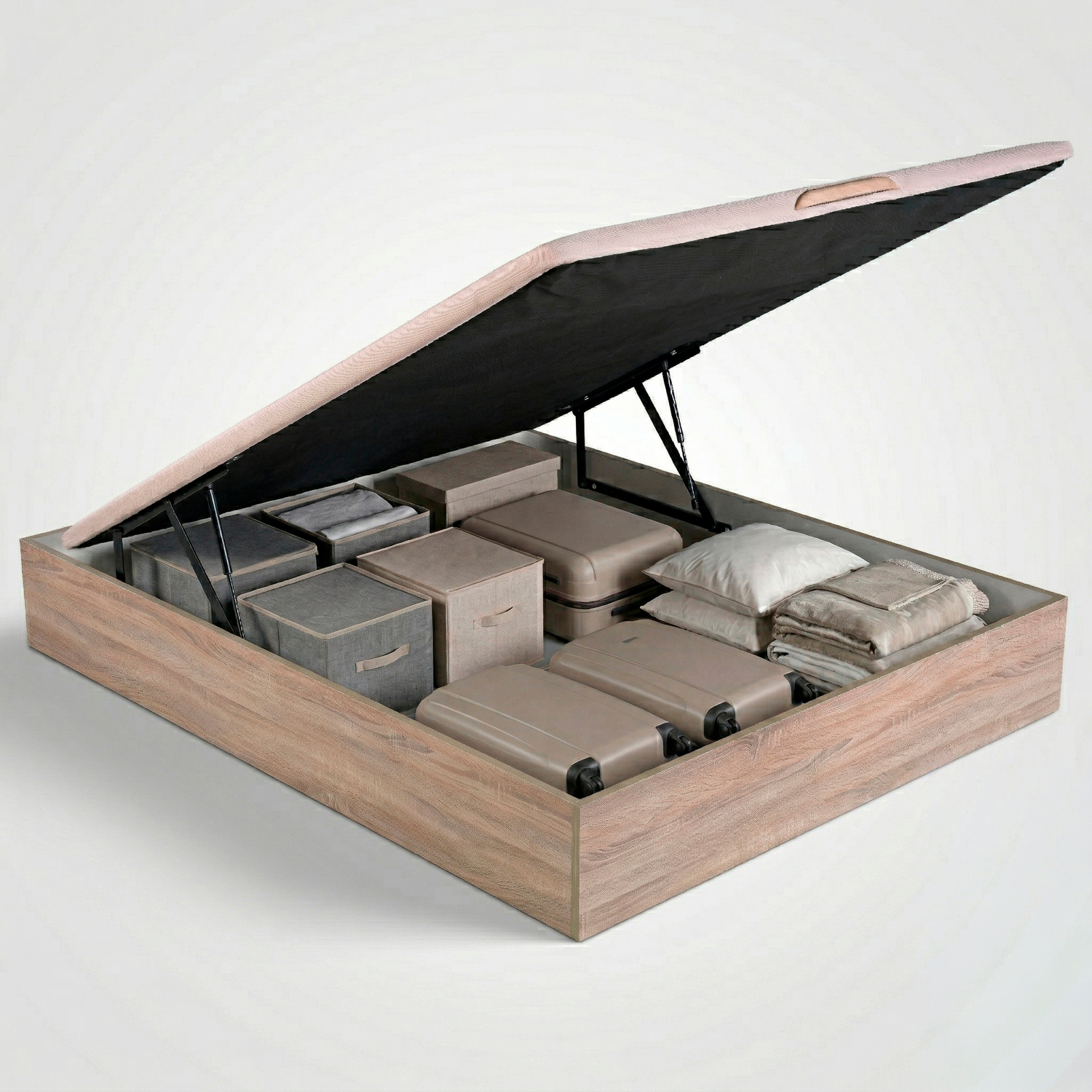 Una base de cama de madera con el somier levantado, mostrando cajas organizadas, maletas y ropa de cama doblada.