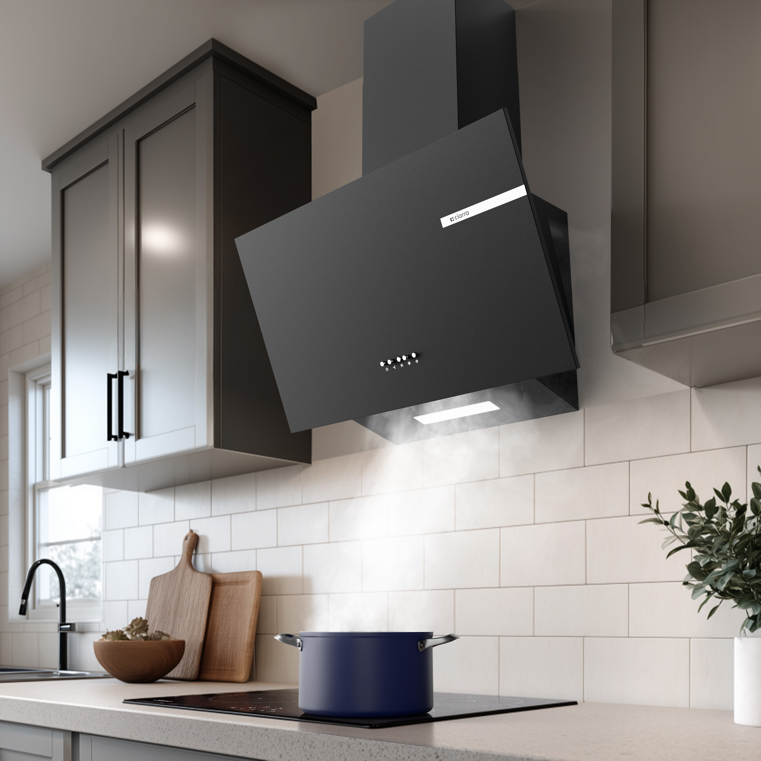 Una olla azul oscura en una estufa con vapor elevándose hacia una campana extractora negra moderna en una cocina.