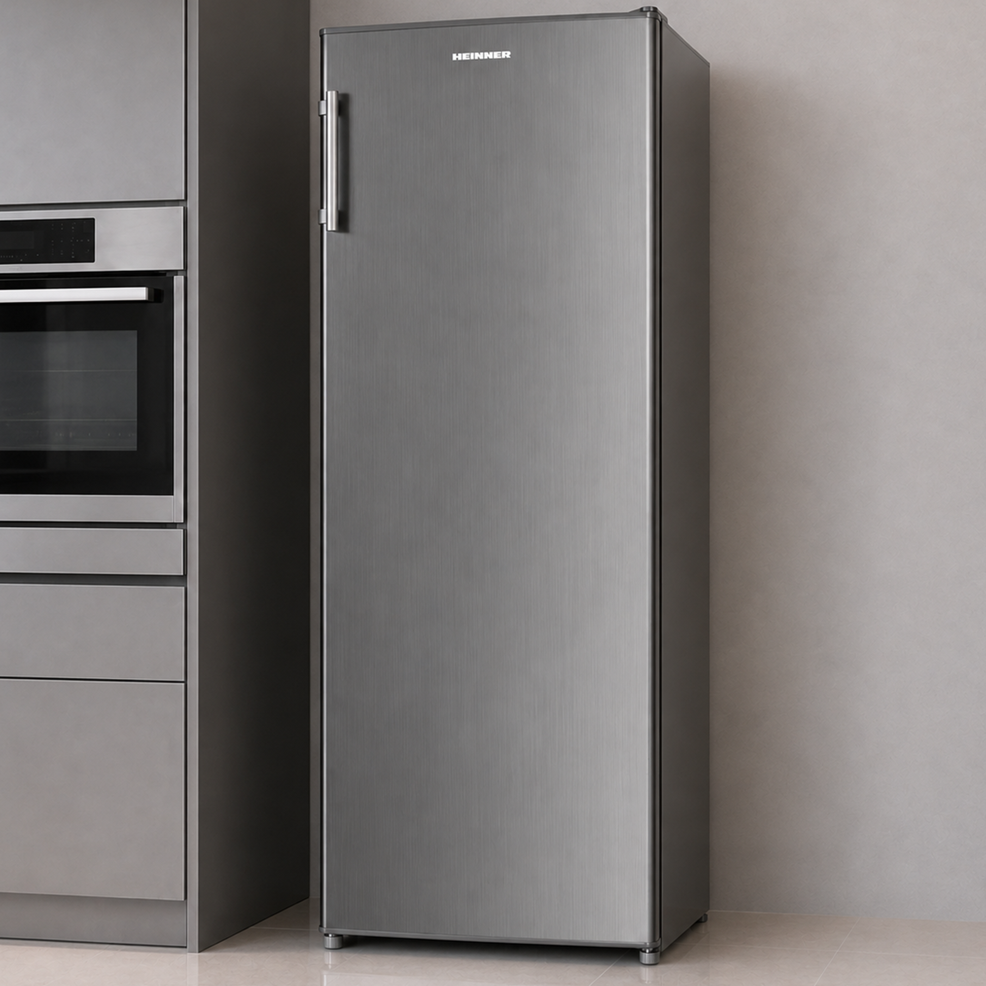 Ein silberner Standkühlschrank steht in einer modernen Küche neben einem Ofen.