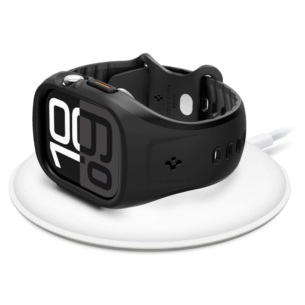 Uno smartwatch nero in una custodia robusta è appoggiato in piano su una base di ricarica wireless bianca.