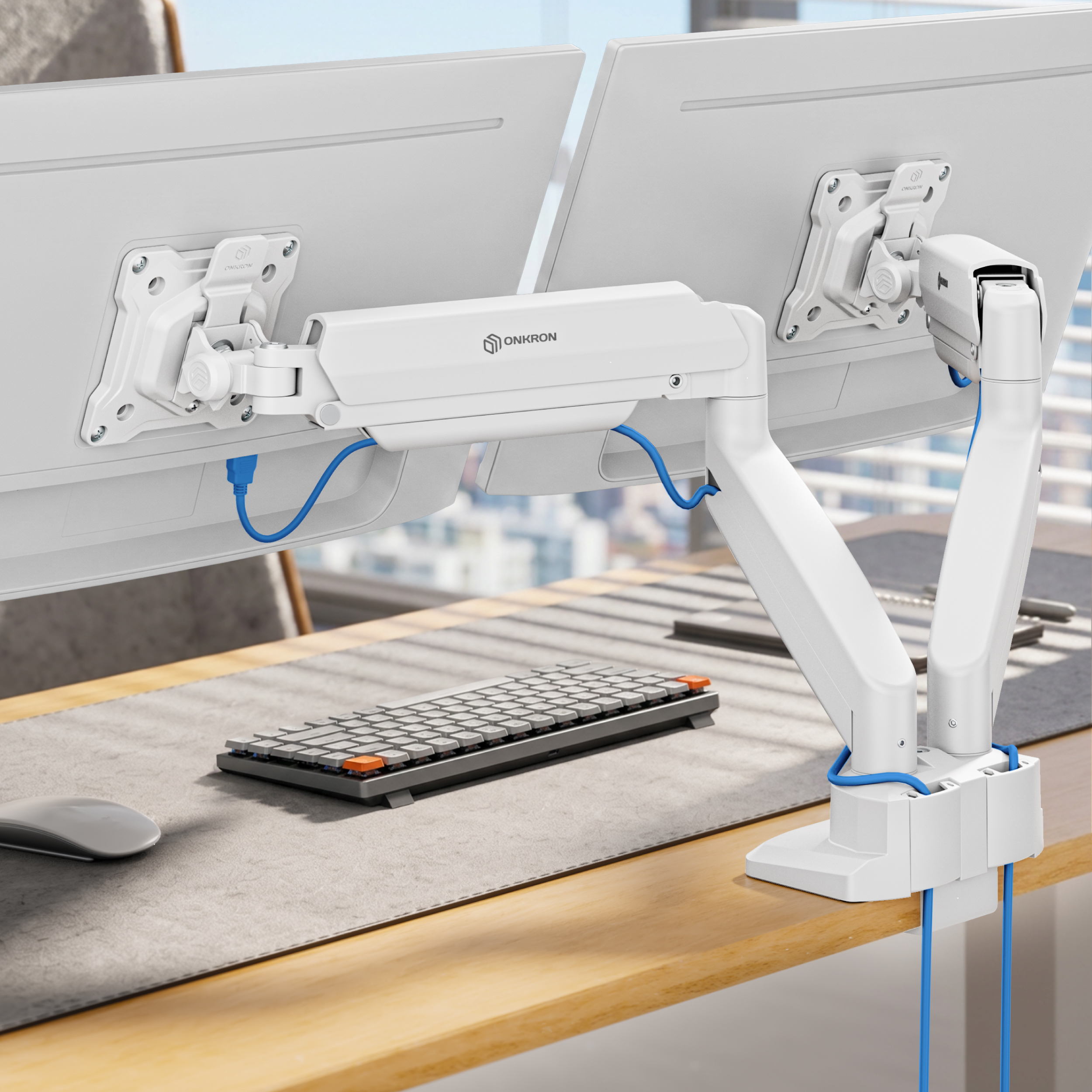 Ein weißer Doppel-Monitorarm ist an einem Schreibtisch befestigt und hält zwei Bildschirme über einer grauen Matte.