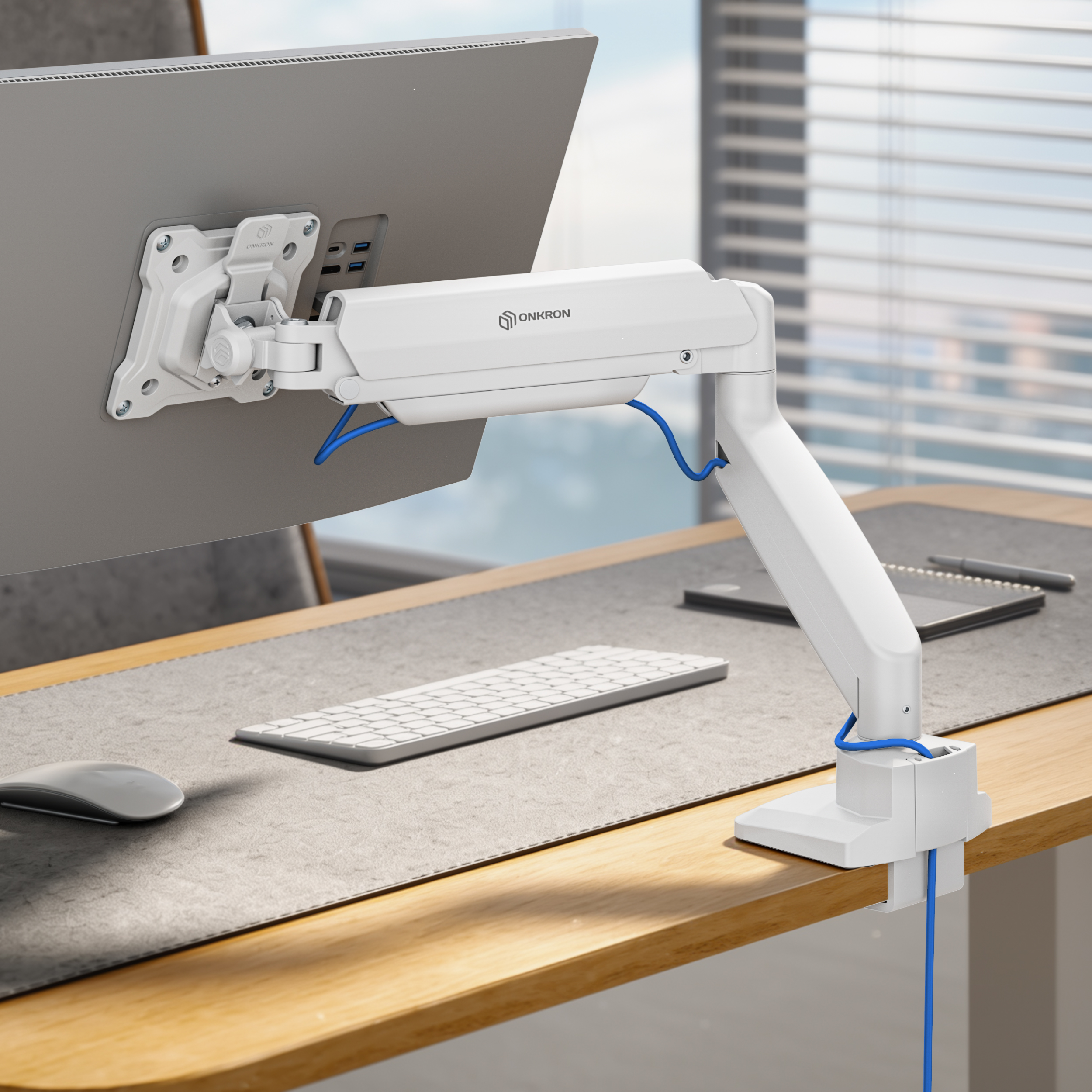 Ein weißer Monitorarm ist an einem Schreibtisch befestigt und hält einen grauen Bildschirm.