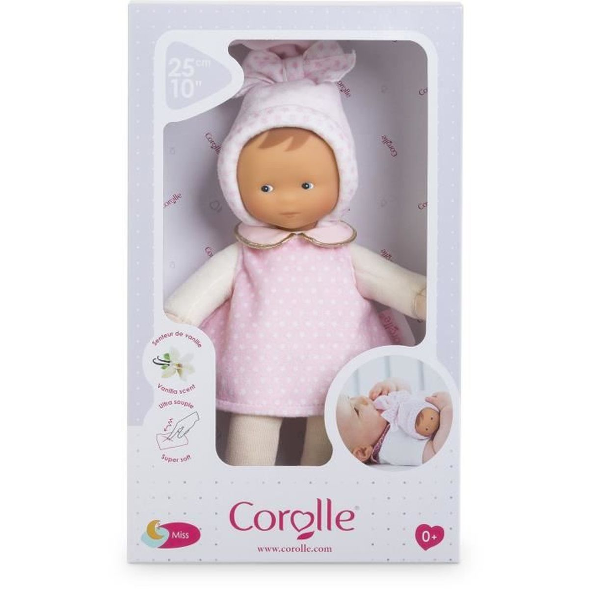 Eine Babypuppe in rosafarbenem Pünktchenkleid und Haube in der Markenverpackung.