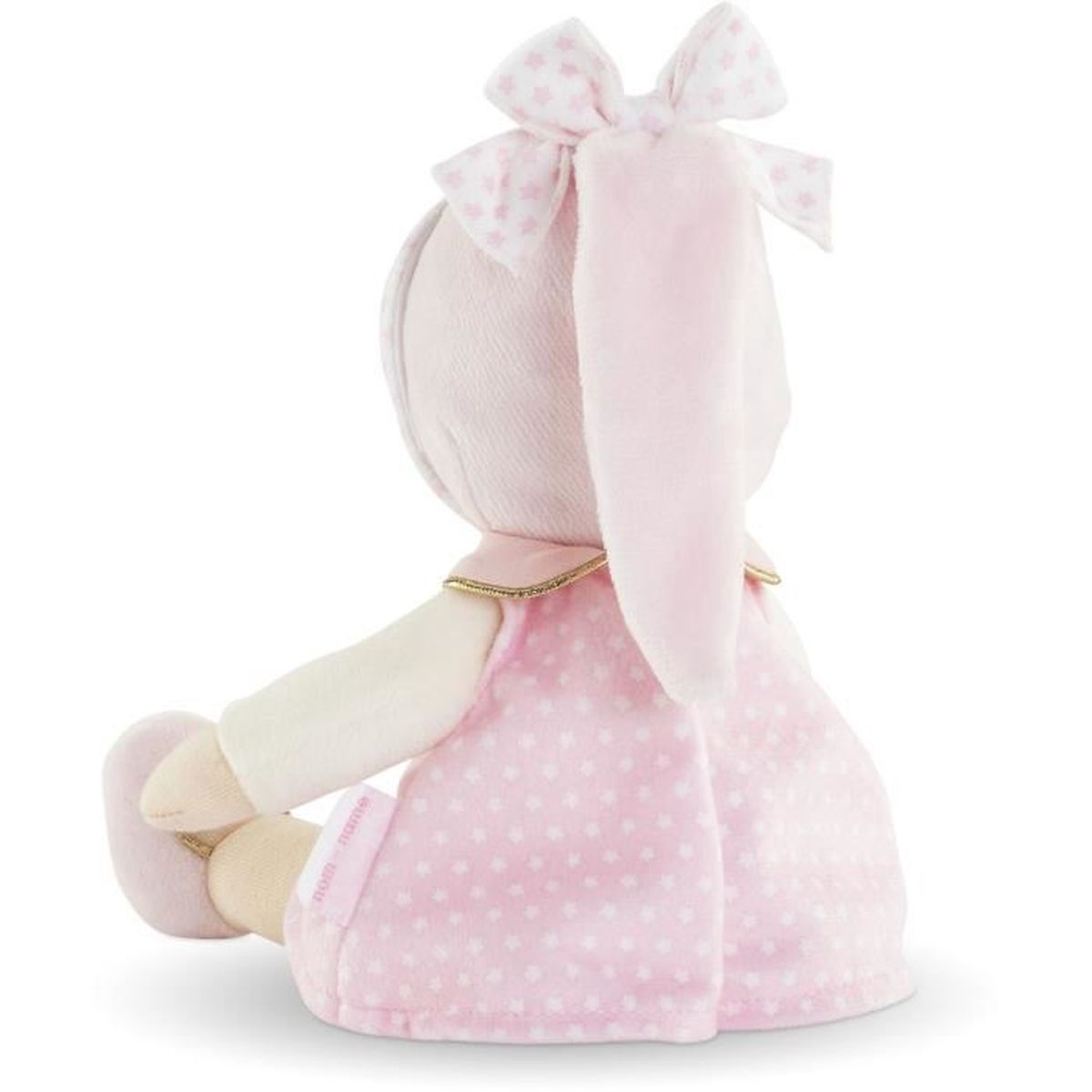 Rückansicht einer sitzenden Plüschpuppe in rosa Kleid mit weißen Sternen und passender Schleife im Haar vor weißem Hintergrund.