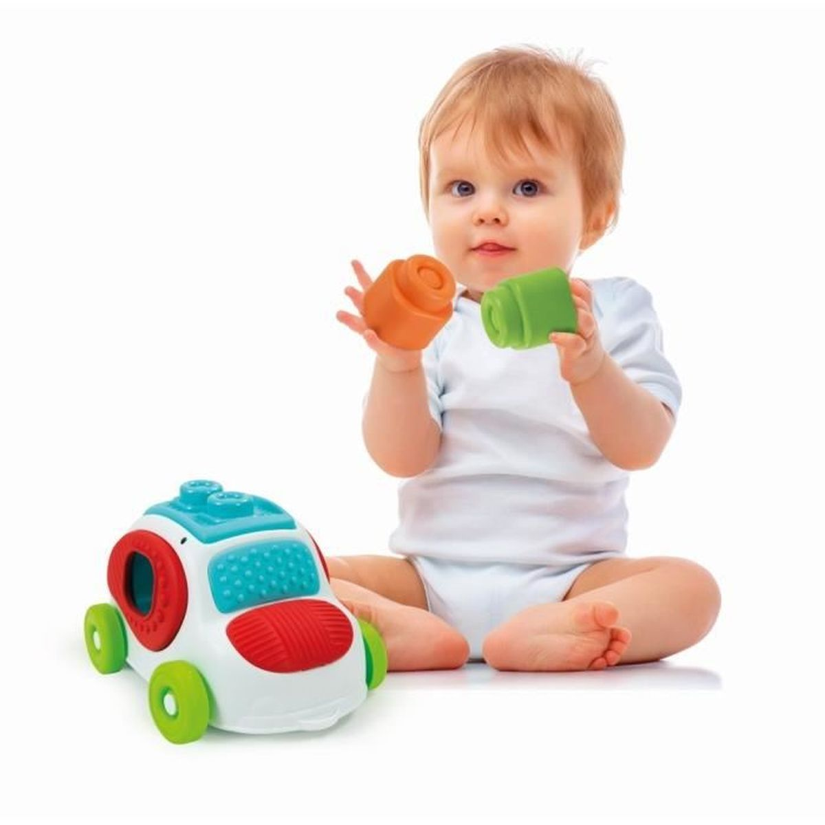 Ein Baby in Weiß spielt mit orange und grünen Blöcken neben einem bunten Spielzeugauto.