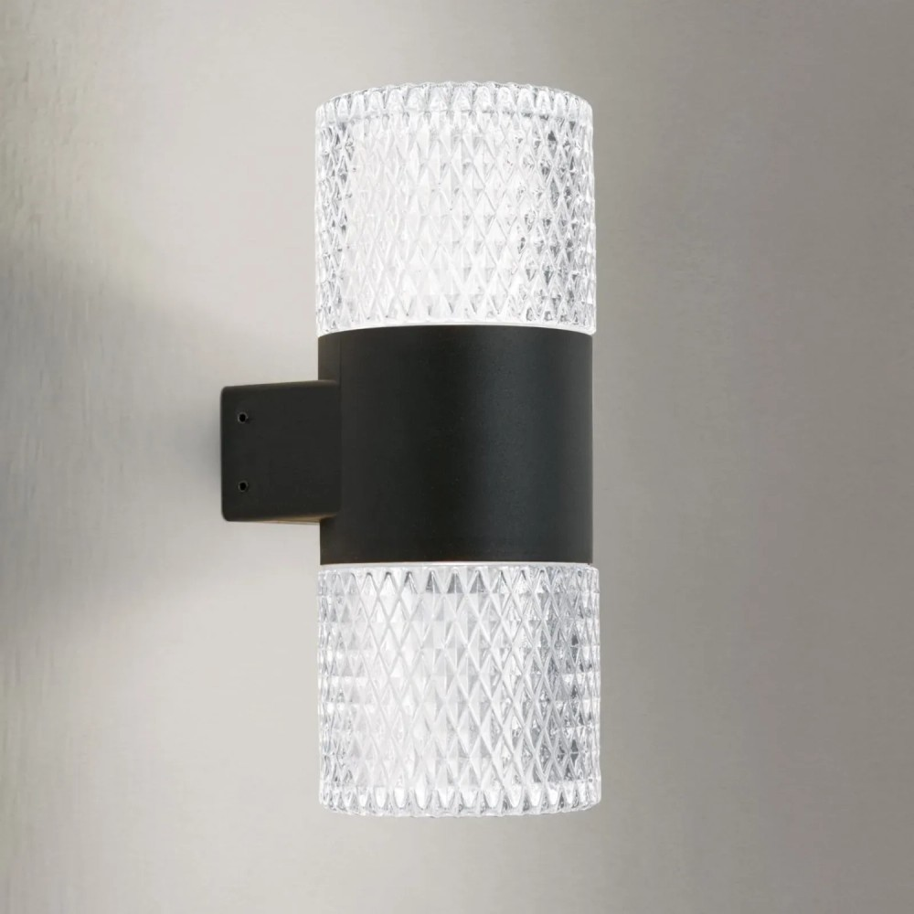 Moderne schwarze Wandleuchte mit strukturierten Glaselementen oben und unten.